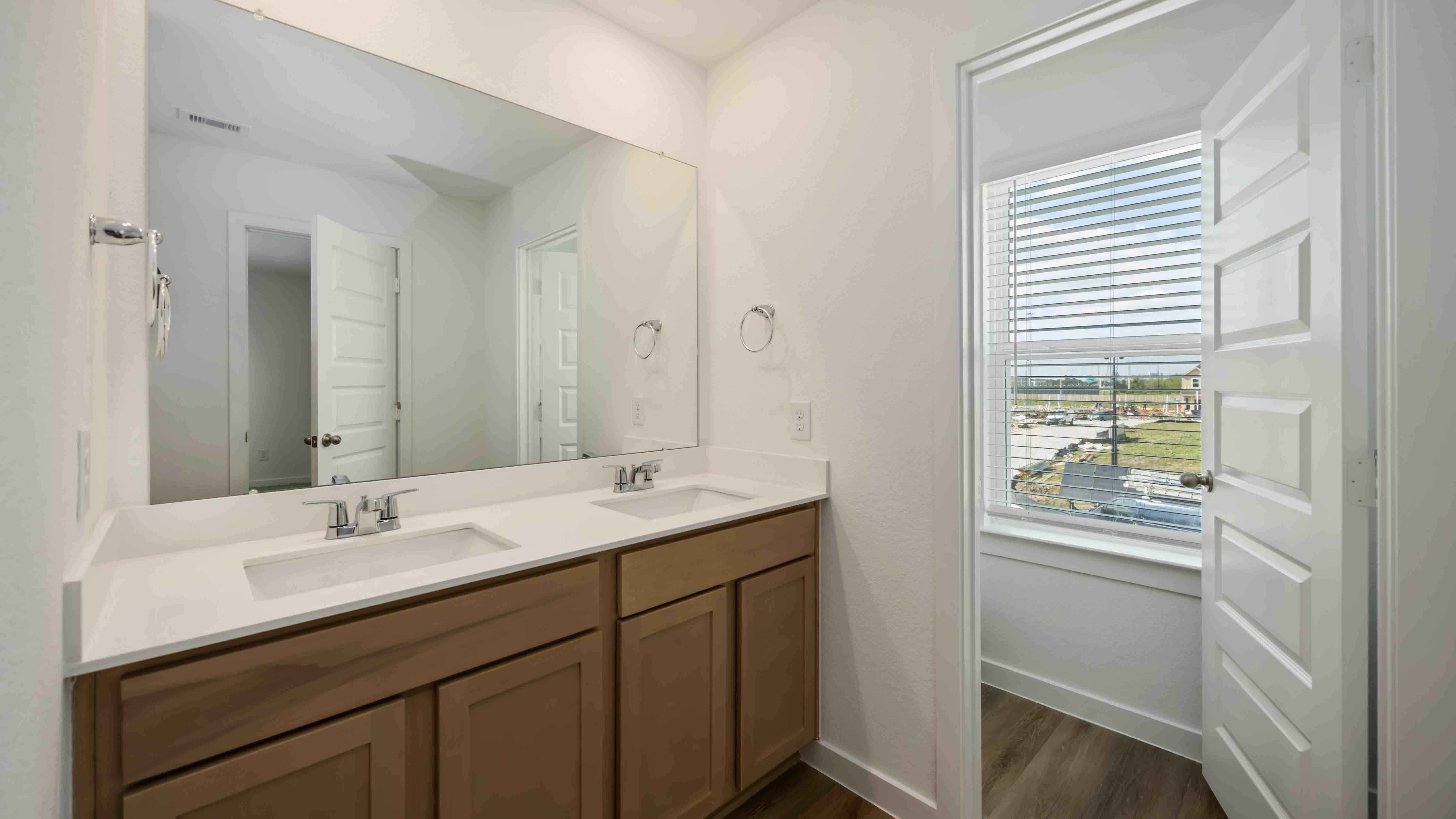 the en-suite primary bathroom has a double vanity and a standing shower