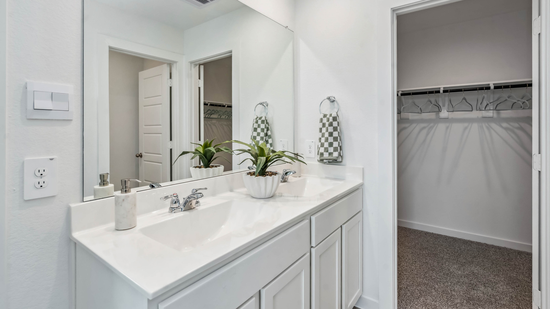 the en-suite primary bathroom has a double vanity and spacious walk-in closet
