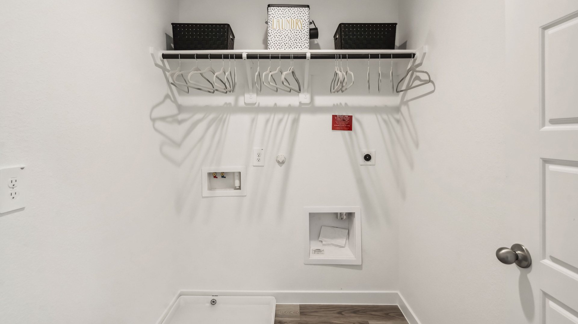 laundry room area with an open shelf and rod for additional storage and hanging clothes