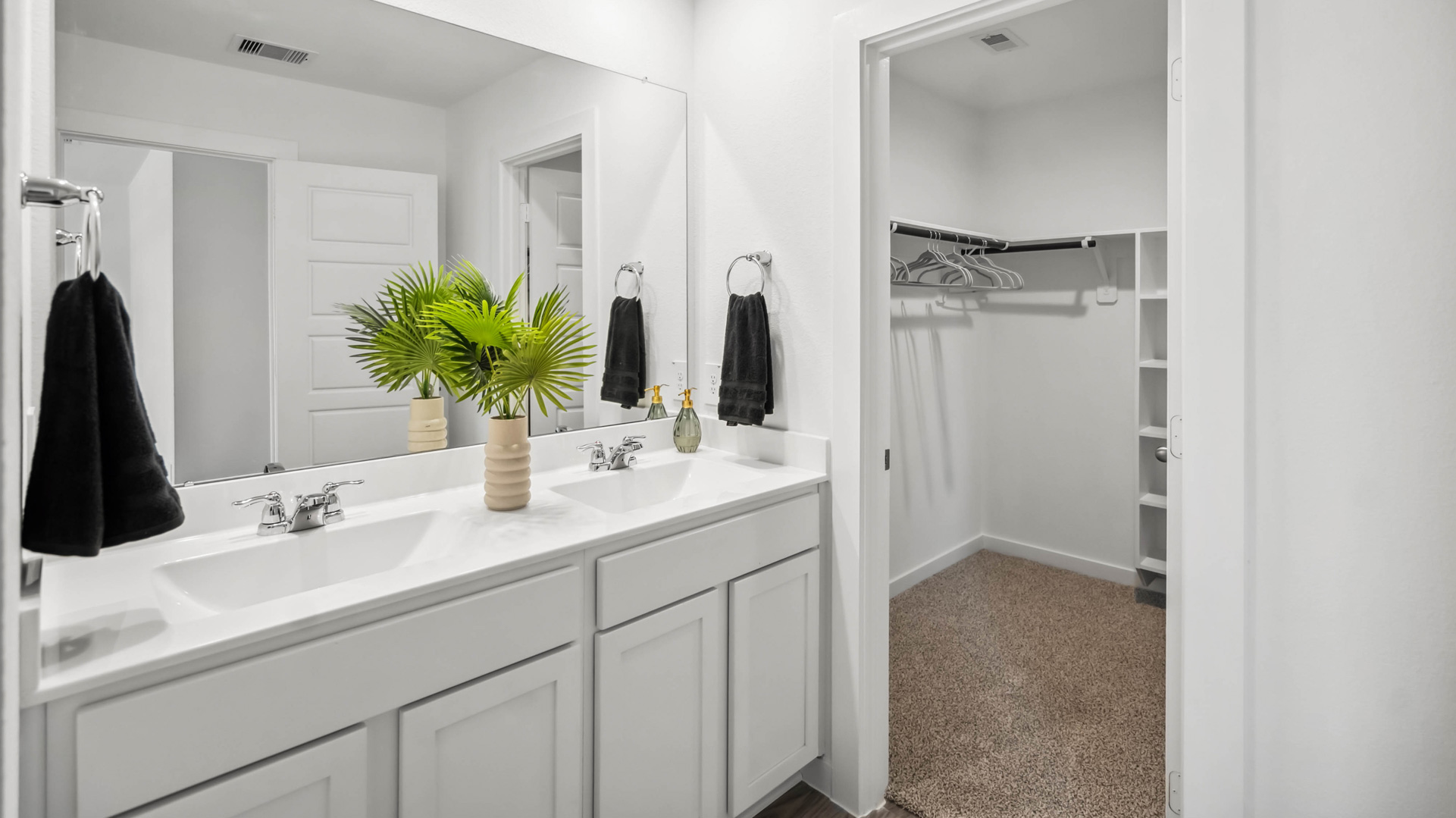 the en-suite primary bathroom has a double vanity and a standing shower