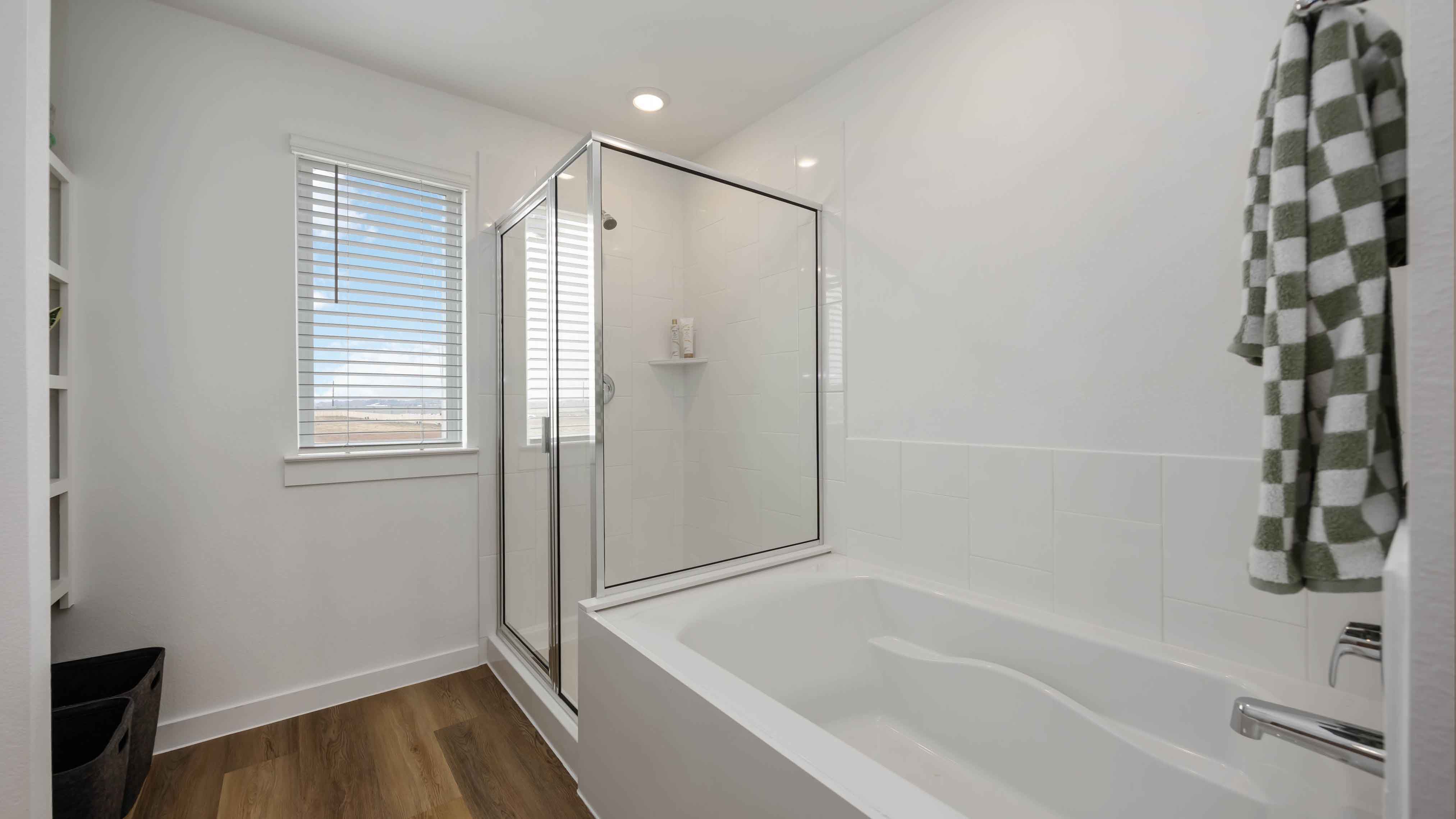 the primary bathroom with a window and a tub