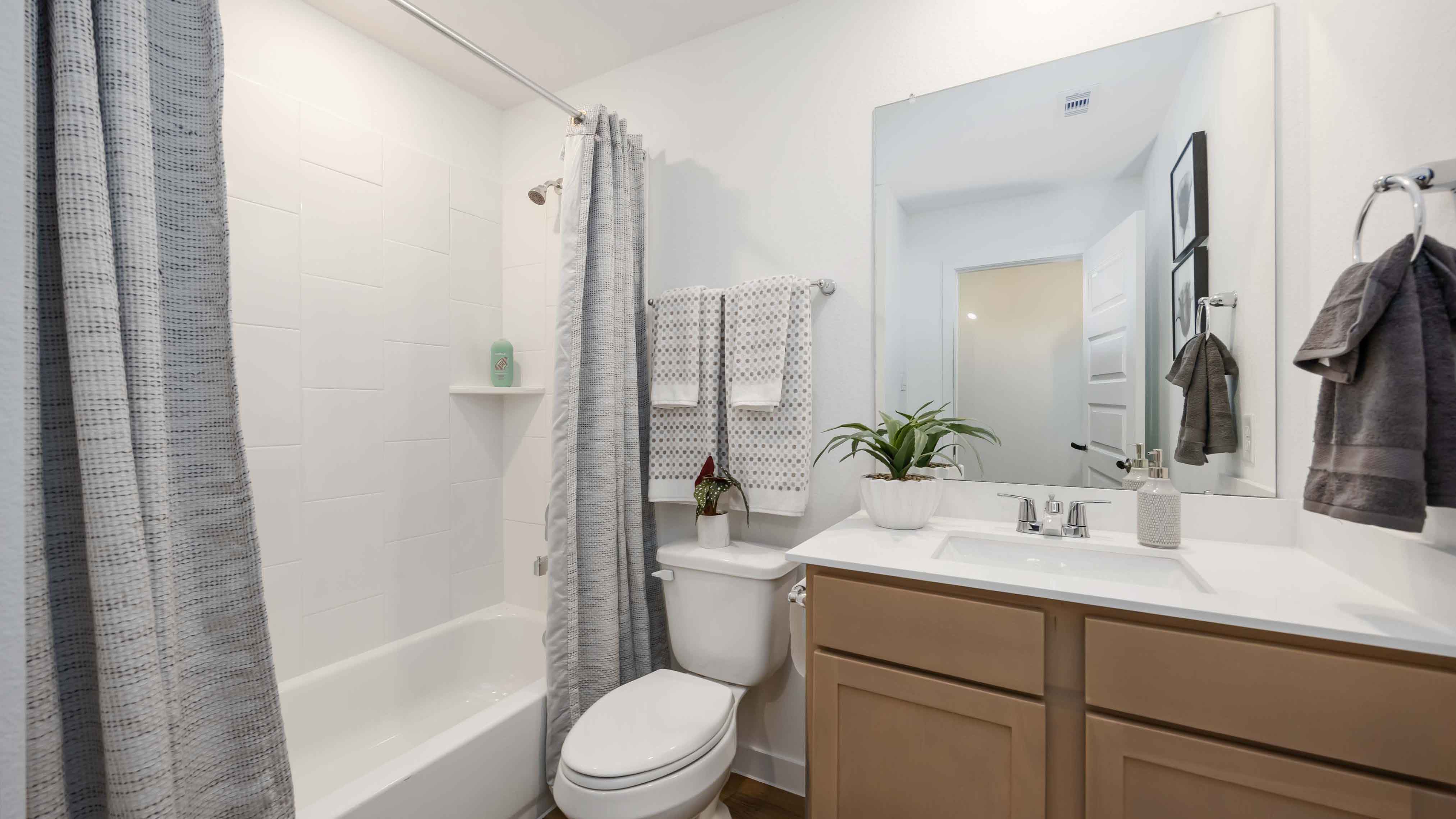 a spacious secondary bathroom with one sink vanity and standing tub