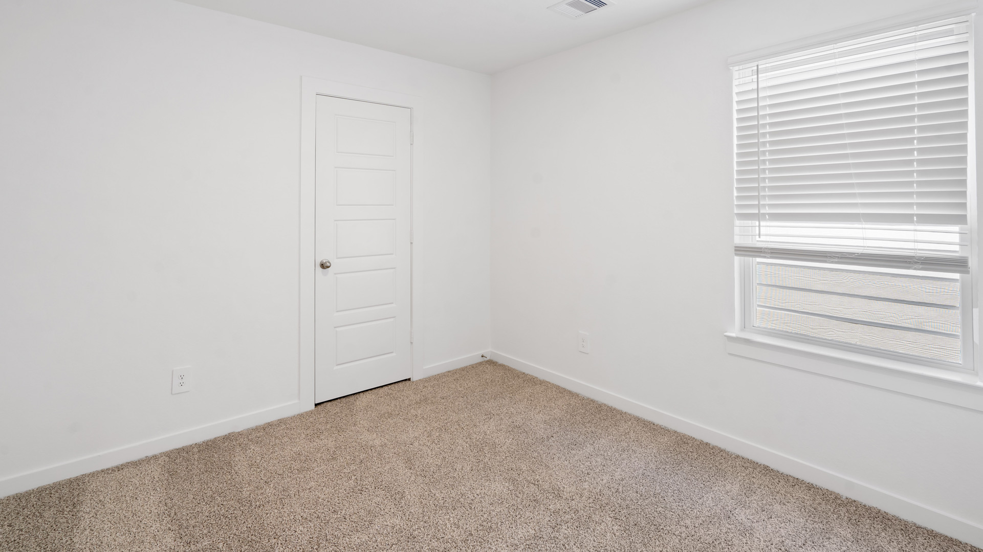 third bedroom has light neutral walls and carpet flooring