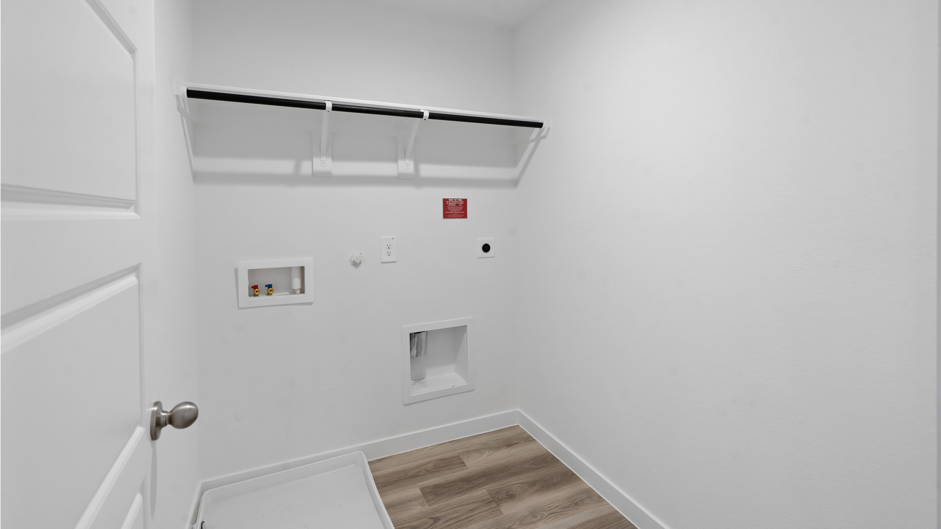 laundry room area with an open shelf and rod for additional storage and hanging clothes