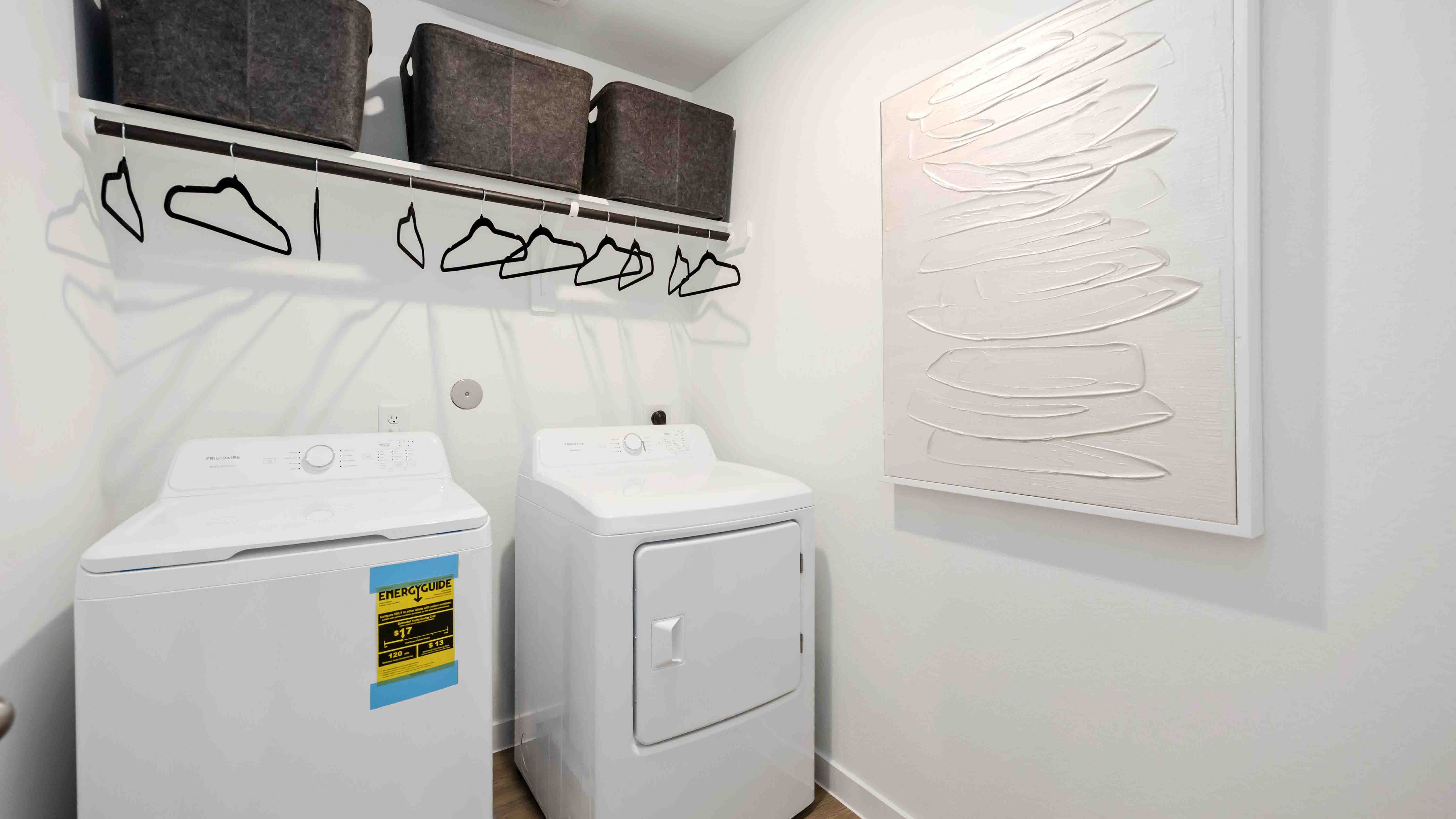 laundry room area with an open shelf and rod for additional storage and hanging clothes