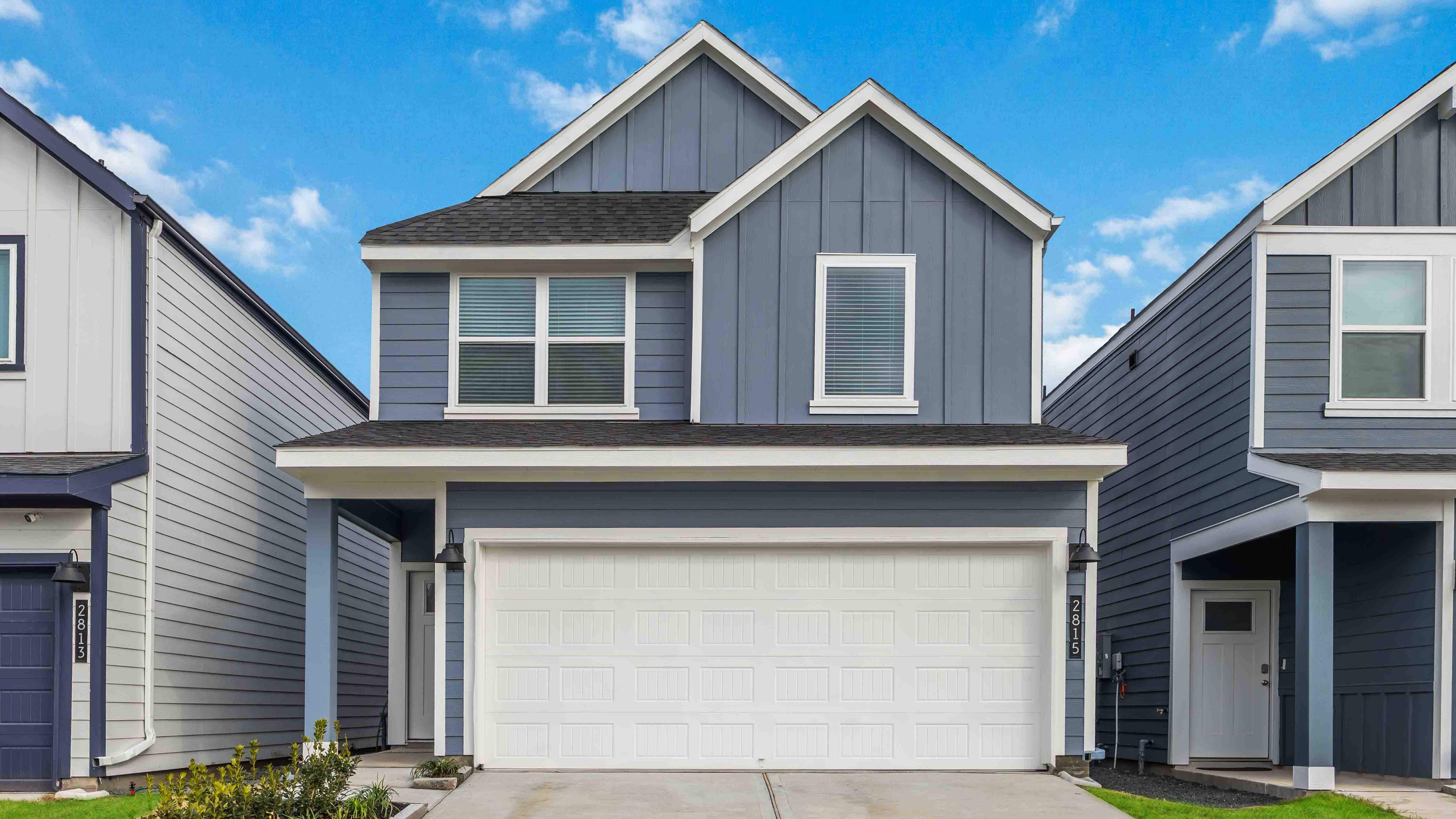 two story home with three large windows on the front of the home