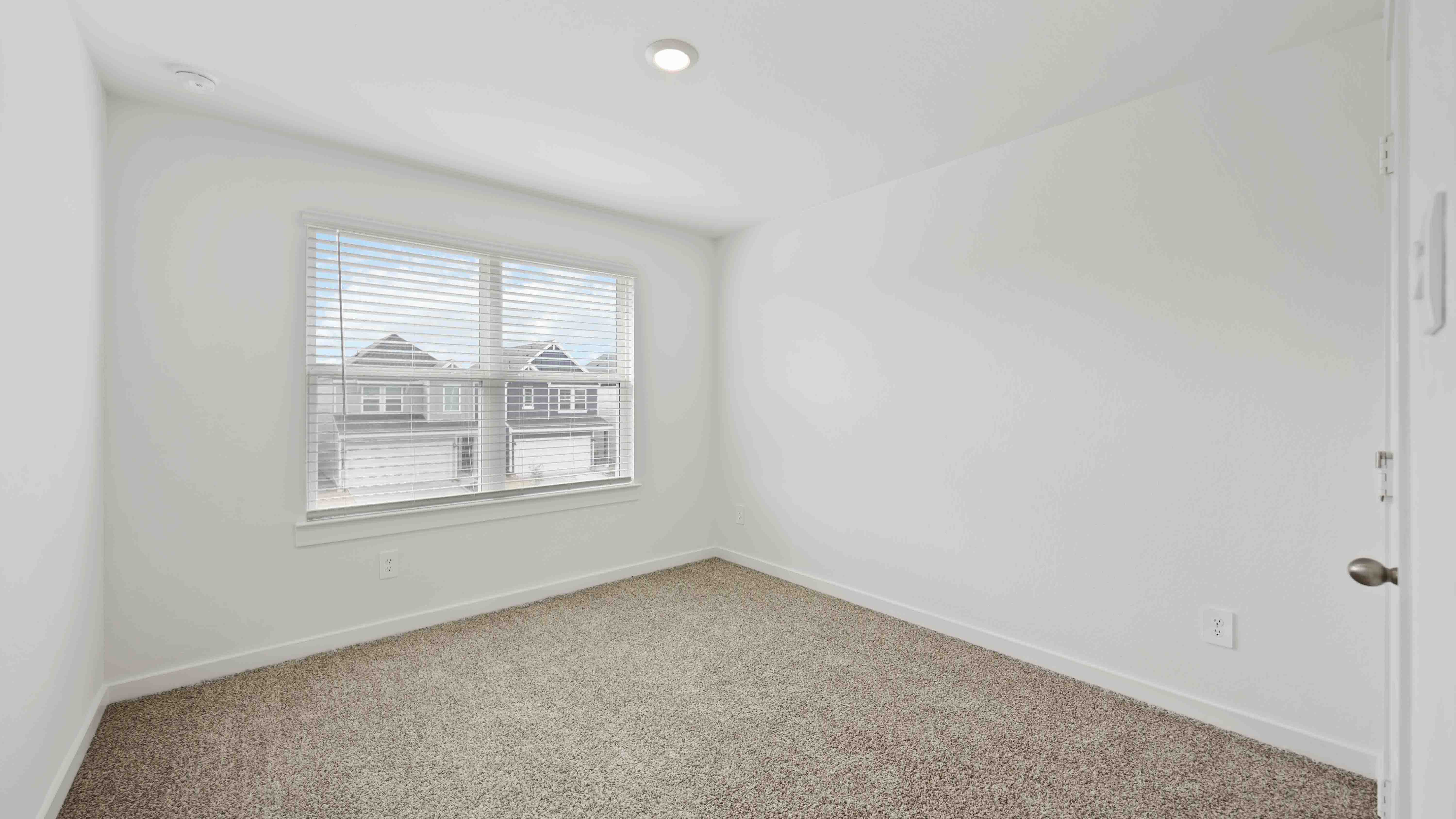 third bedroom has light neutral walls and carpet flooring