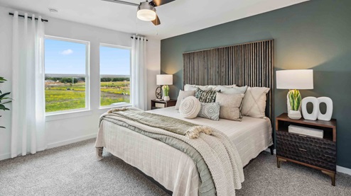 spacious primary bedroom has two large windows that bring in natural light to your new room