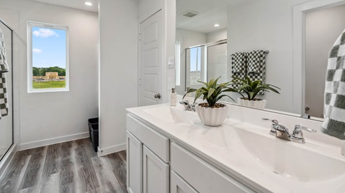 a large mirror is located over the spacious double vanity in the primary bathroom