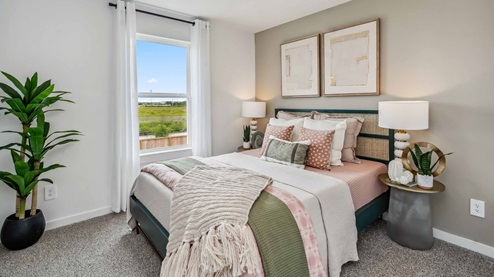 secondary bedroom located at the back of the home with ample space and a view of the backyard