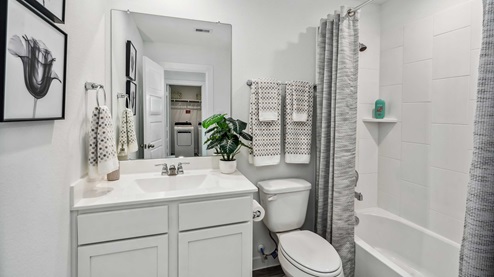 second full bathroom located between the two secondary bedrooms, with a shower/tub combo and a mirror over the single vanity