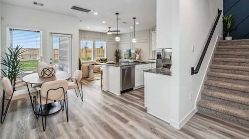 view of open floorplan on the first level, with carpet stairs taking you to the second floor living spaces