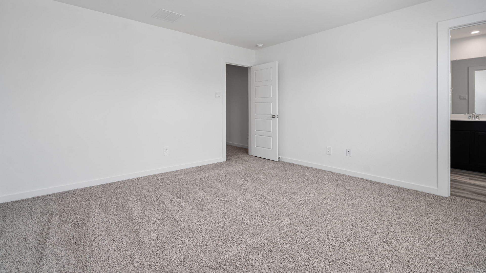 the primary bedroom has carpet flooring and light neutral walls