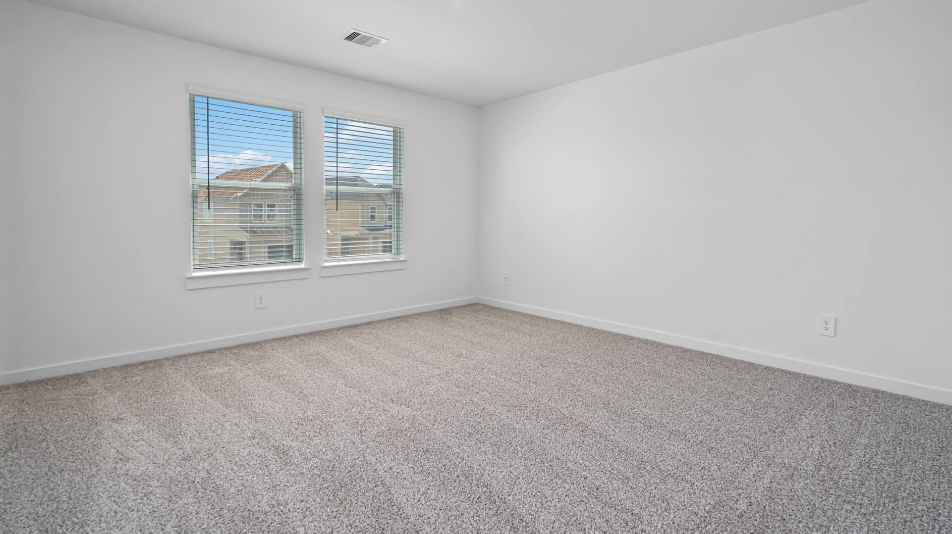 a spacious primary bedroom is located upstairs and has two large windows for natural light