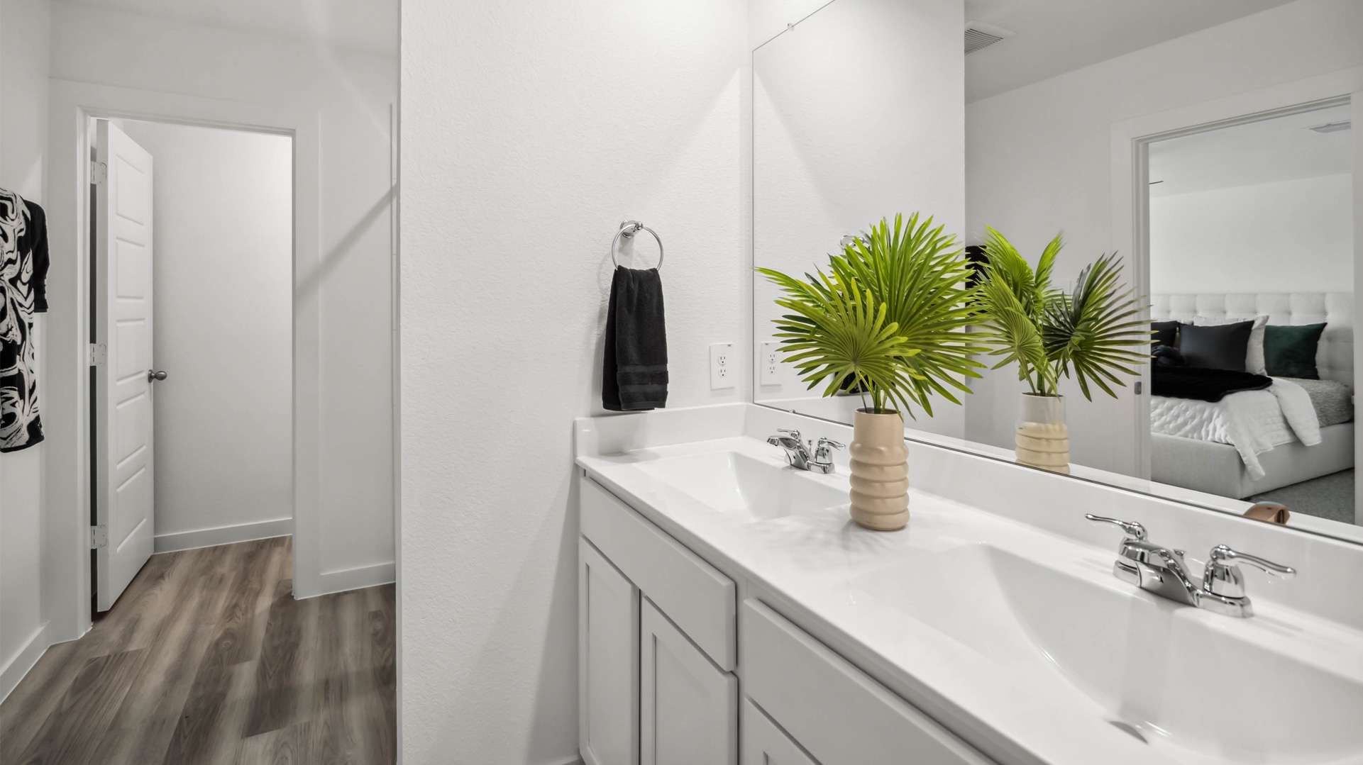 a large mirror is located over the double vanity in the primary bathroom