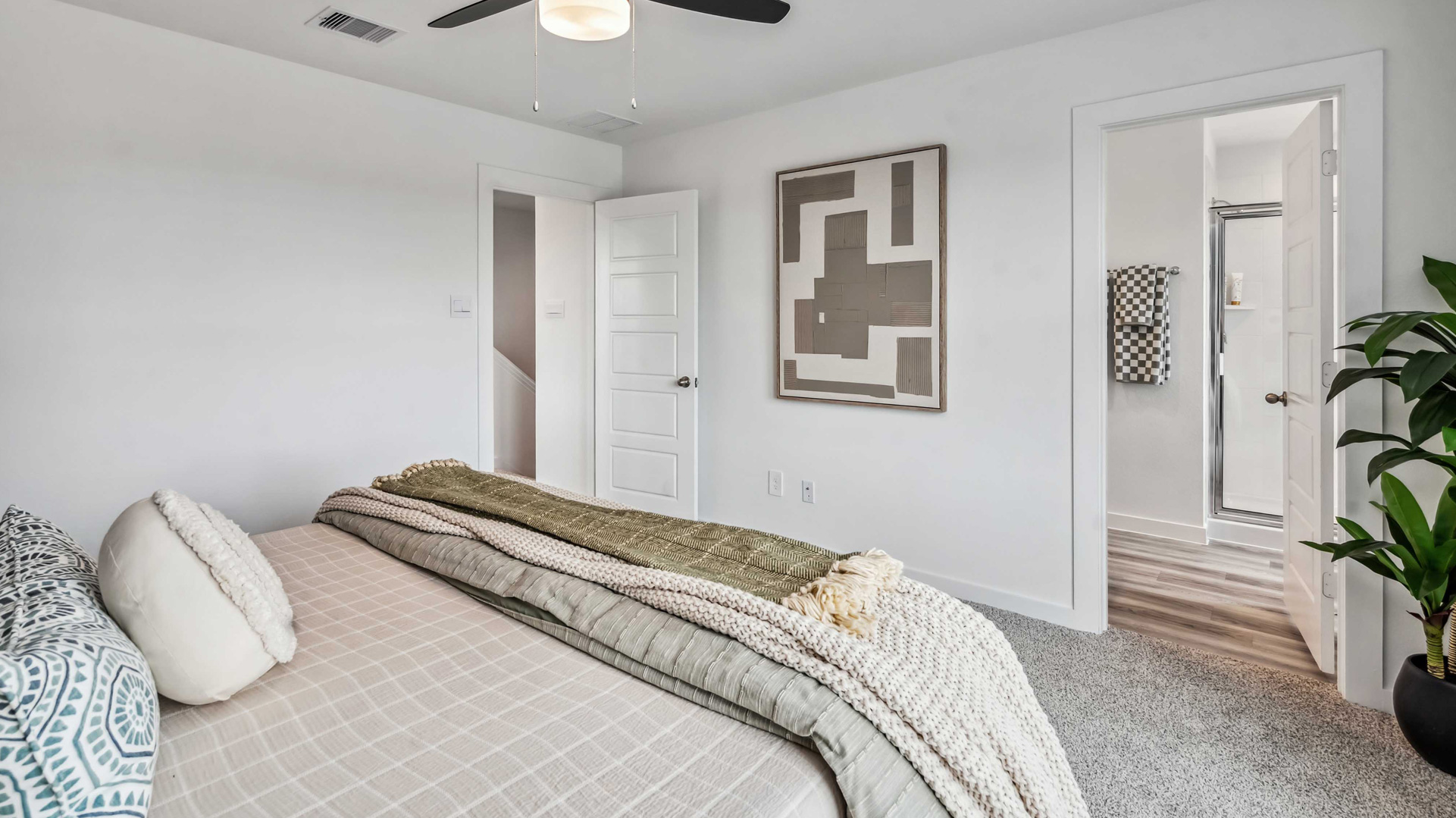 the spacious primary suite comfortably fits a king size bed and additional bedroom furniture