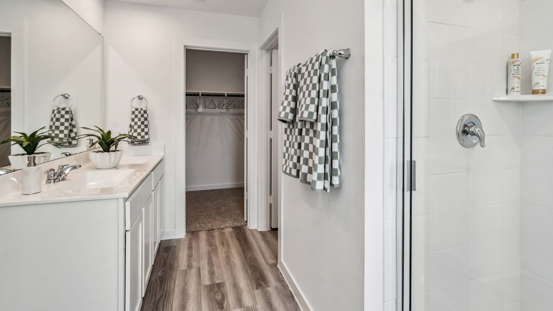 an en-suite primary bathroom has a doble vanity and walk-in shower