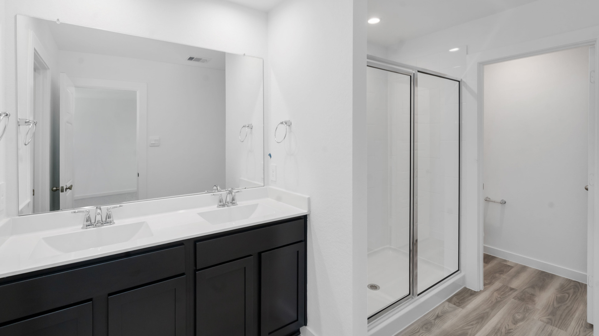 en-suite primary bathroom with a double vanity and walk-in shower