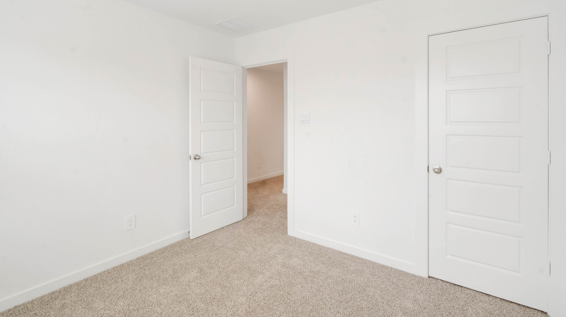 second bedroom has light neutral walls and carpet flooring