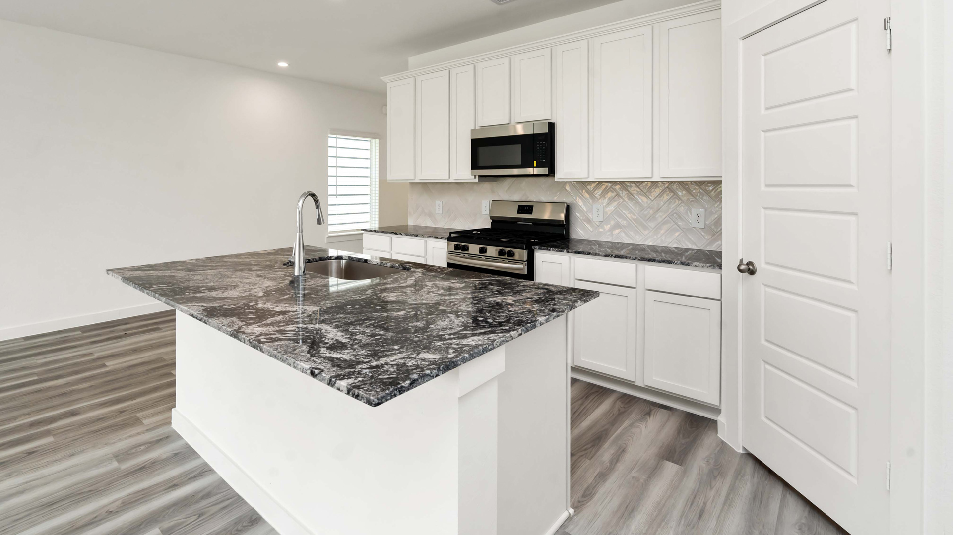 a spacious kitchen island offers the perfect spot for dining or entertaining in your new kitchen