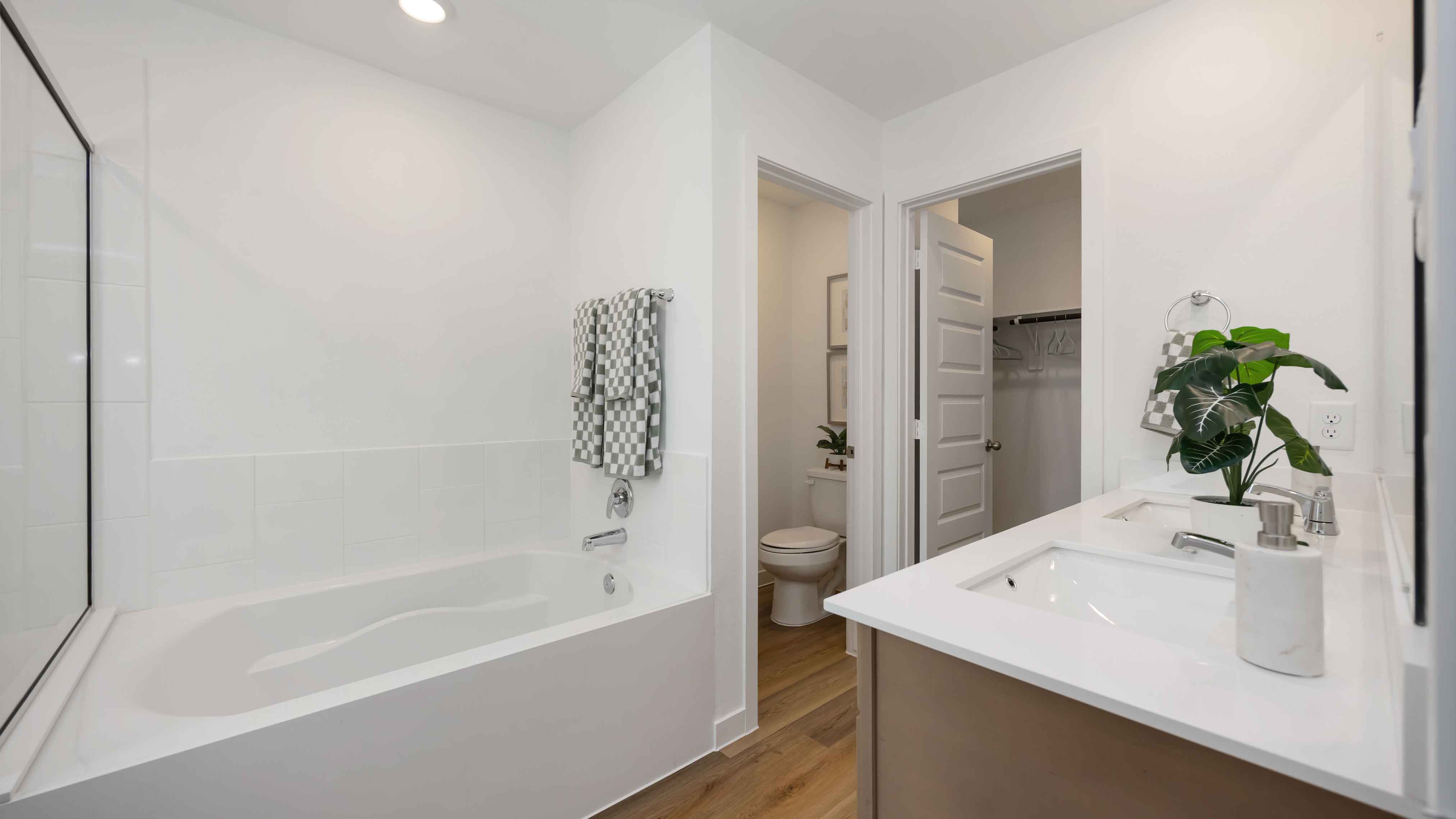 the en-suite primary bathroom has a double vanity and a standing shower and a tub