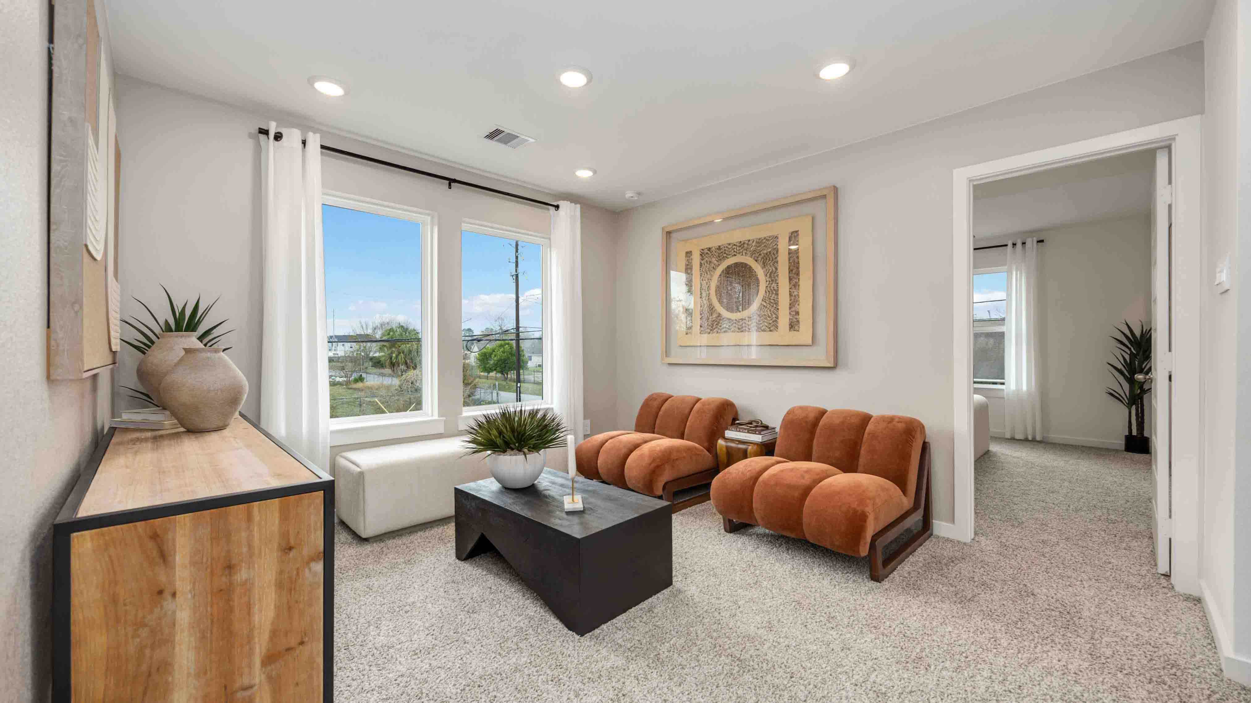 spacious upstairs living area with plenty of natural light from windows overlooking side of the home