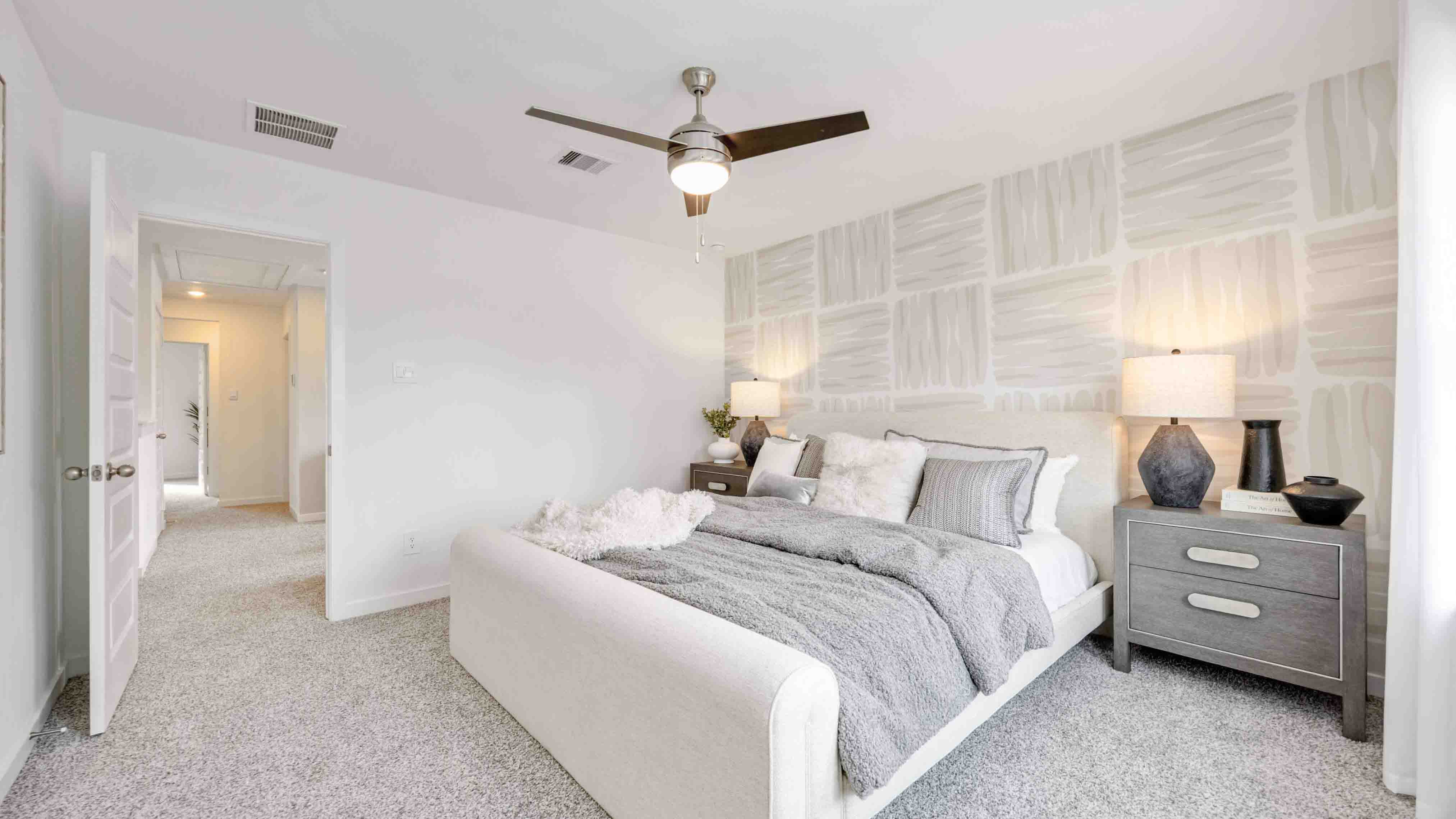 a spacious primary suite comfortably fits a king size bed and additional bedroom furniture