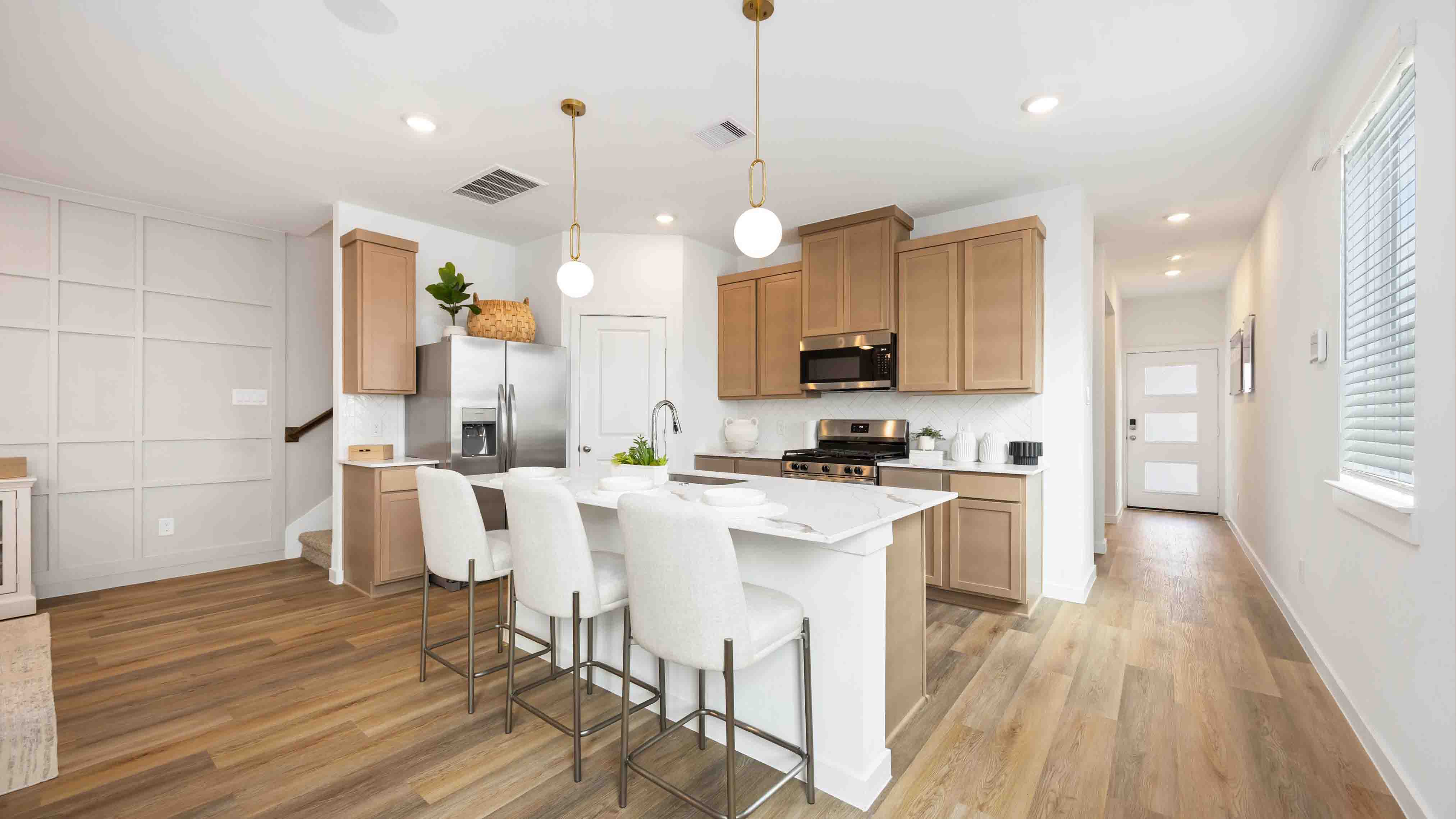 beautiful new kitchen with quartz counters, wood colored cabinets, and herringbone backsplash