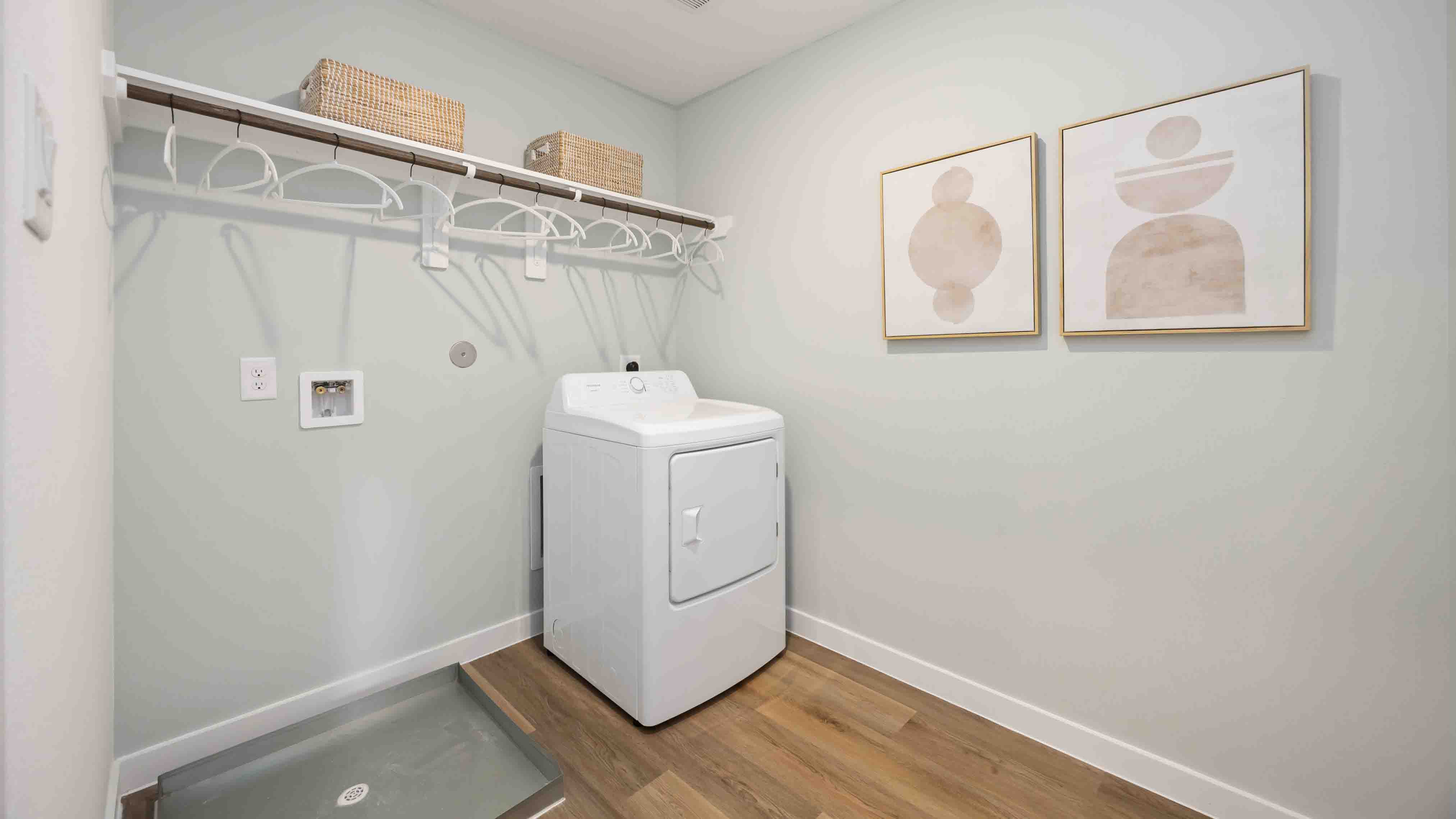 laundry room area with an open shelf and rod for additional storage and hanging clothes