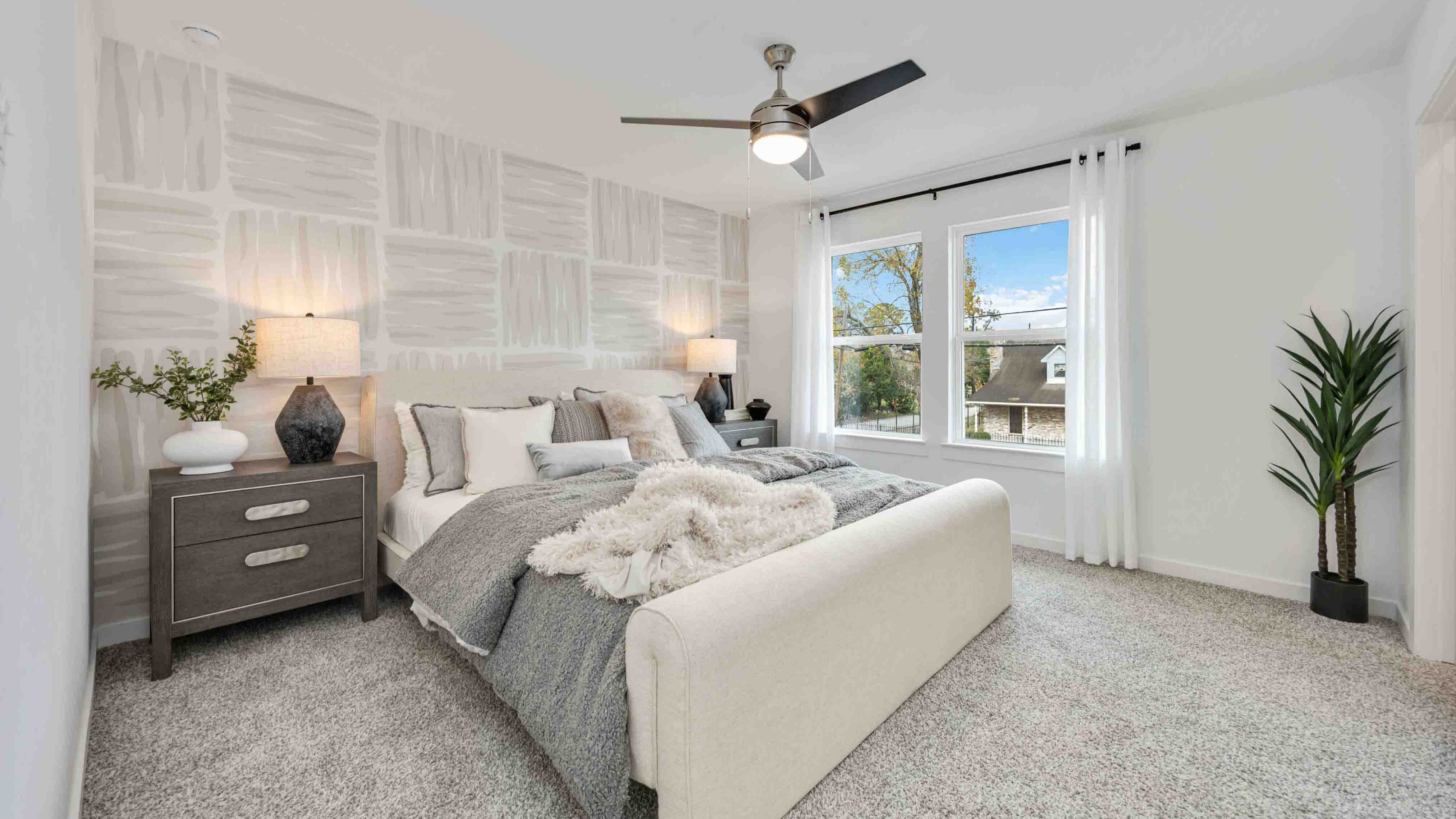 a spacious primary suite comfortably fits a king size bed and additional bedroom furniture