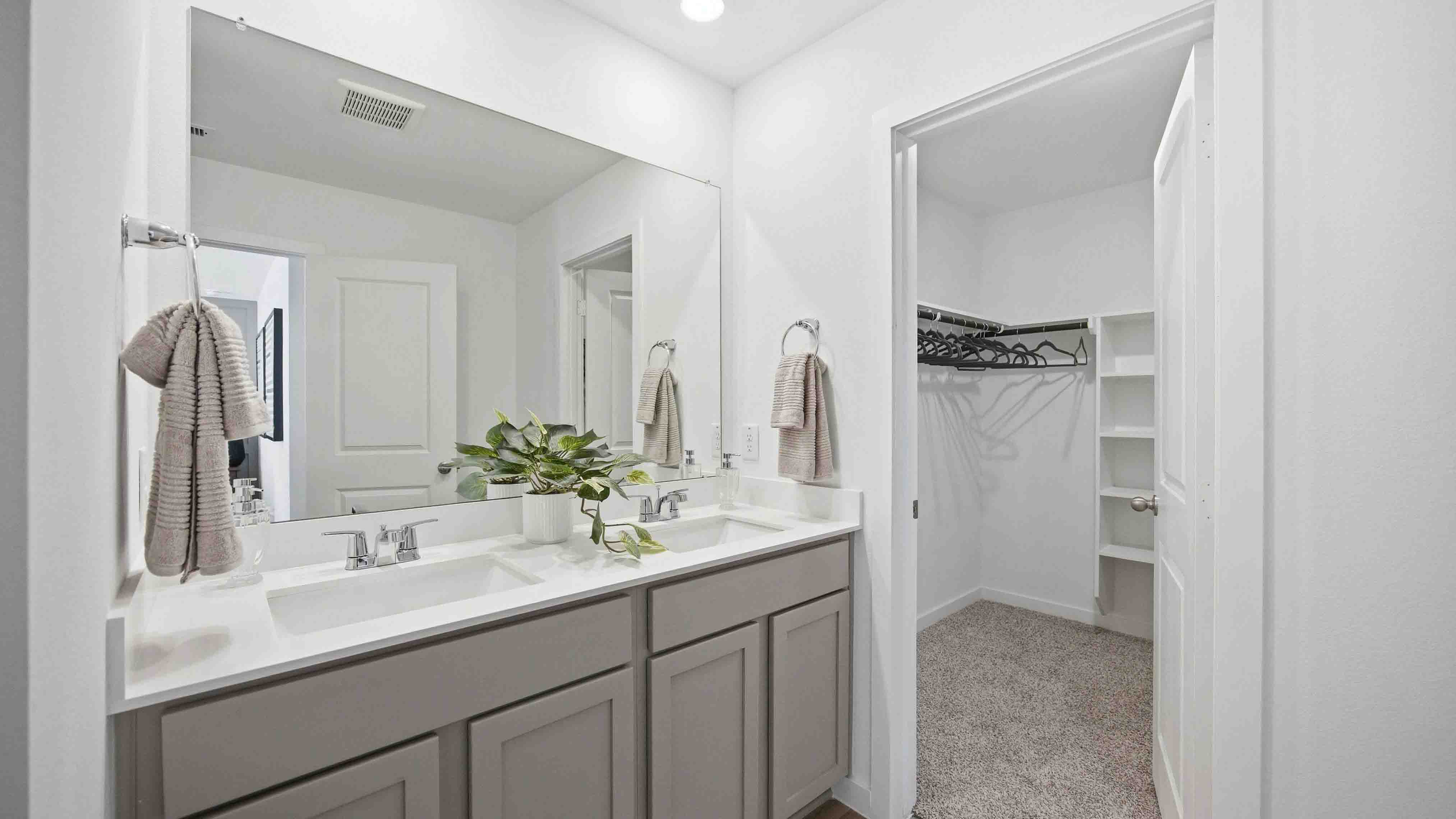 the en-suite primary bathroom has a double vanity and spacious walk-in closet