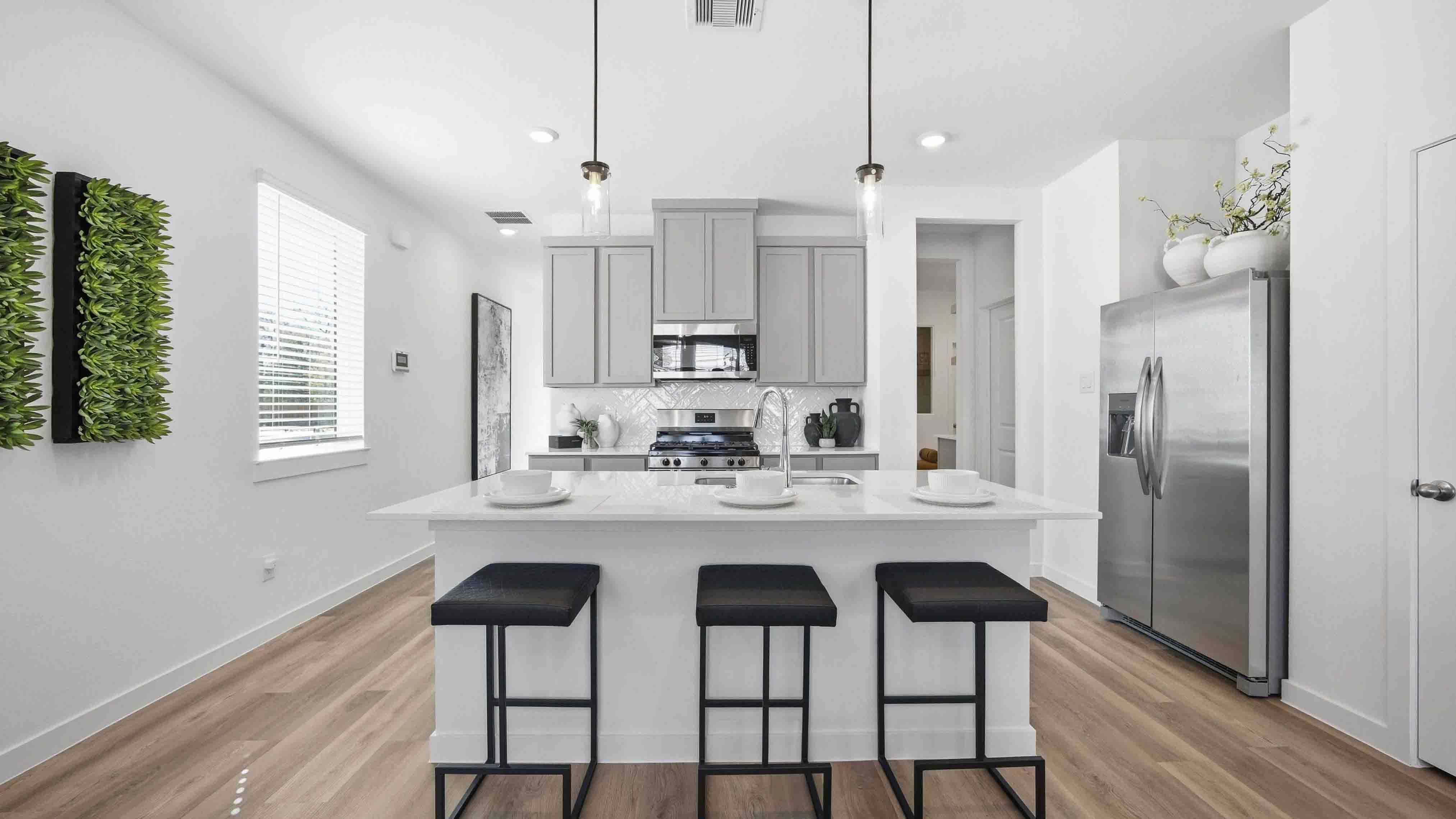 beautiful new kitchen with quartz counter tops, grey cabinets, and herringbone backsplash