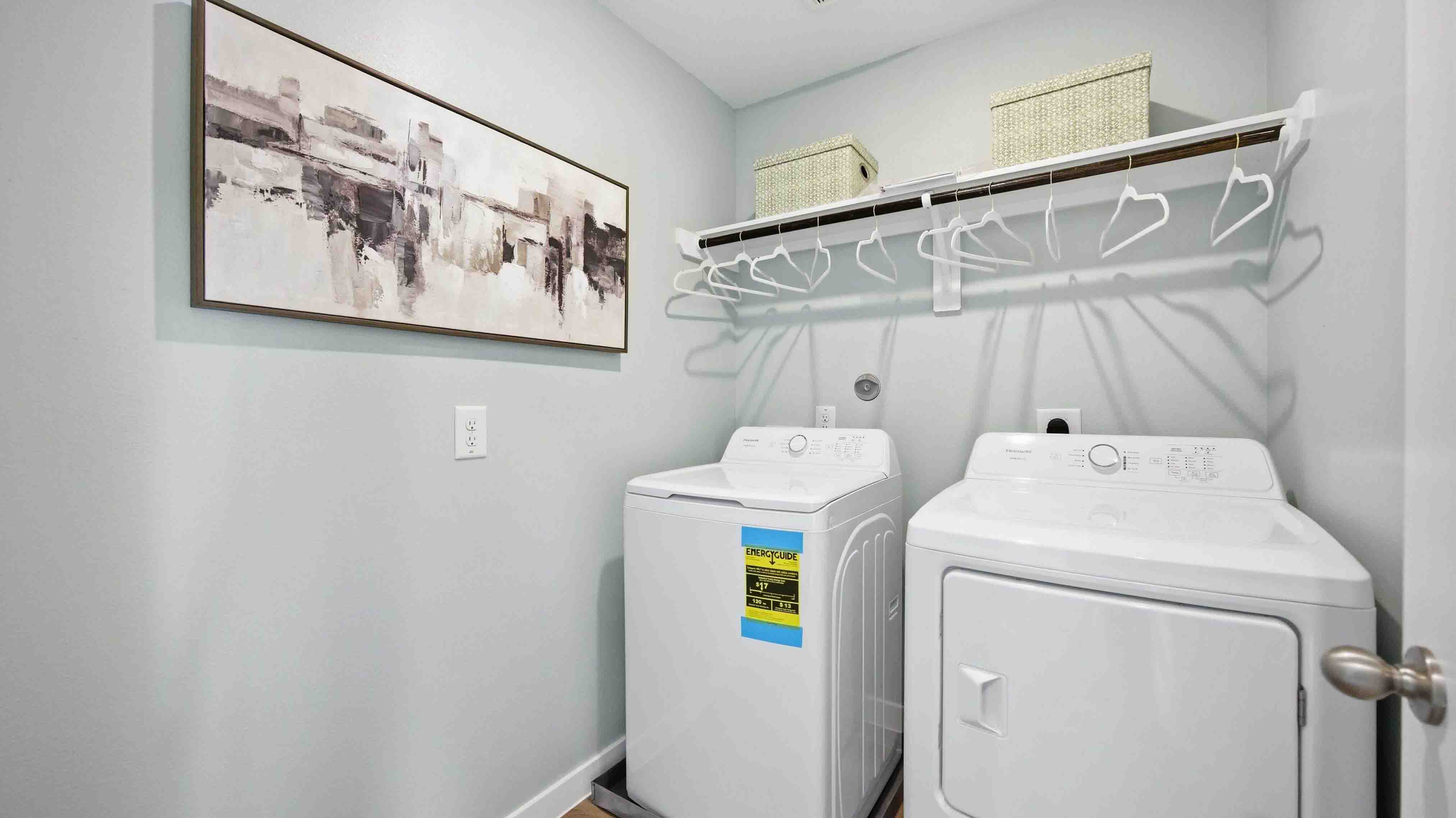 laundry room area with an open shelf and rod for additional storage and hanging clothes