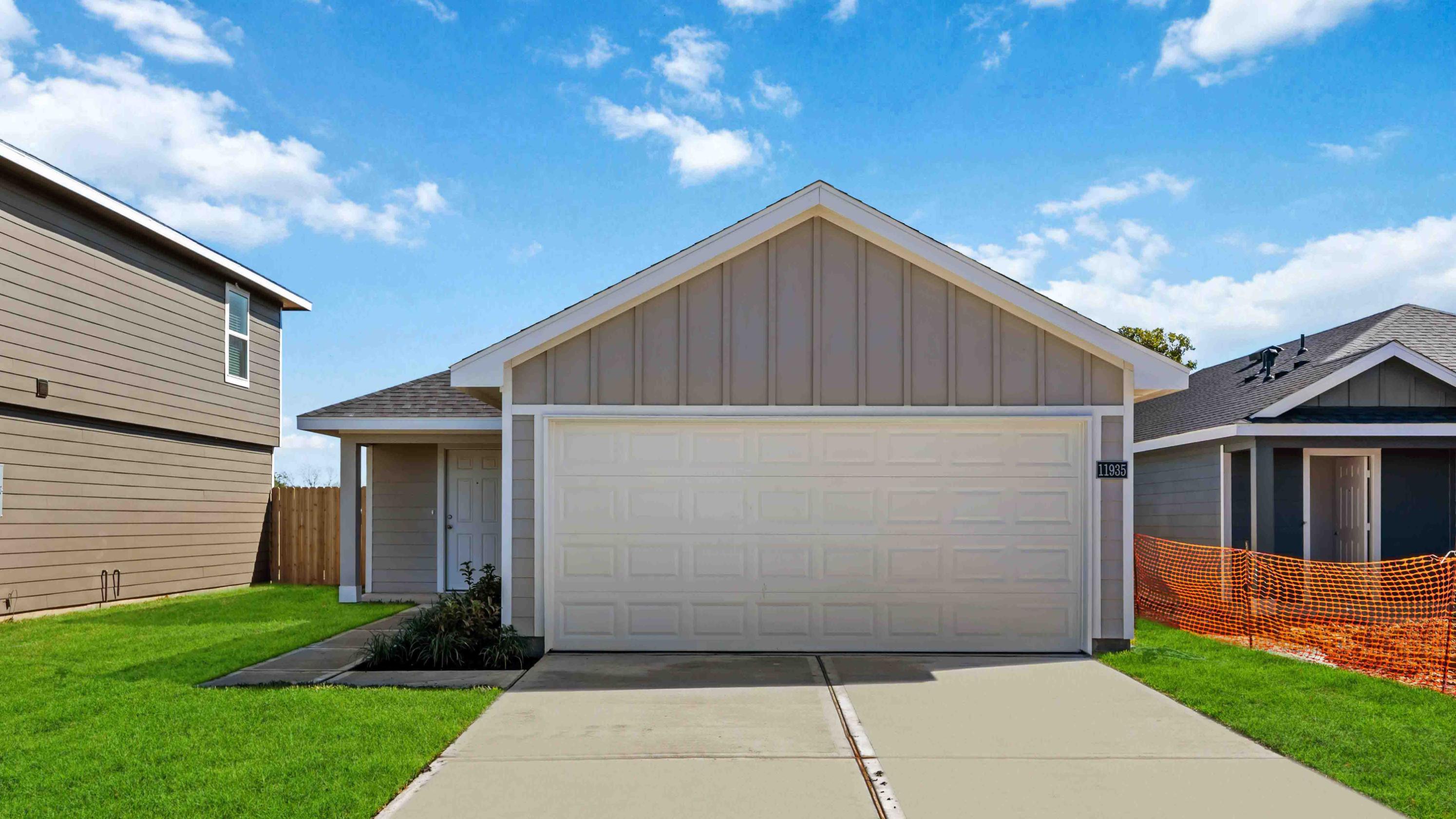 Newly built single story home with modern architecture, a double garage, and landscaped front yard.