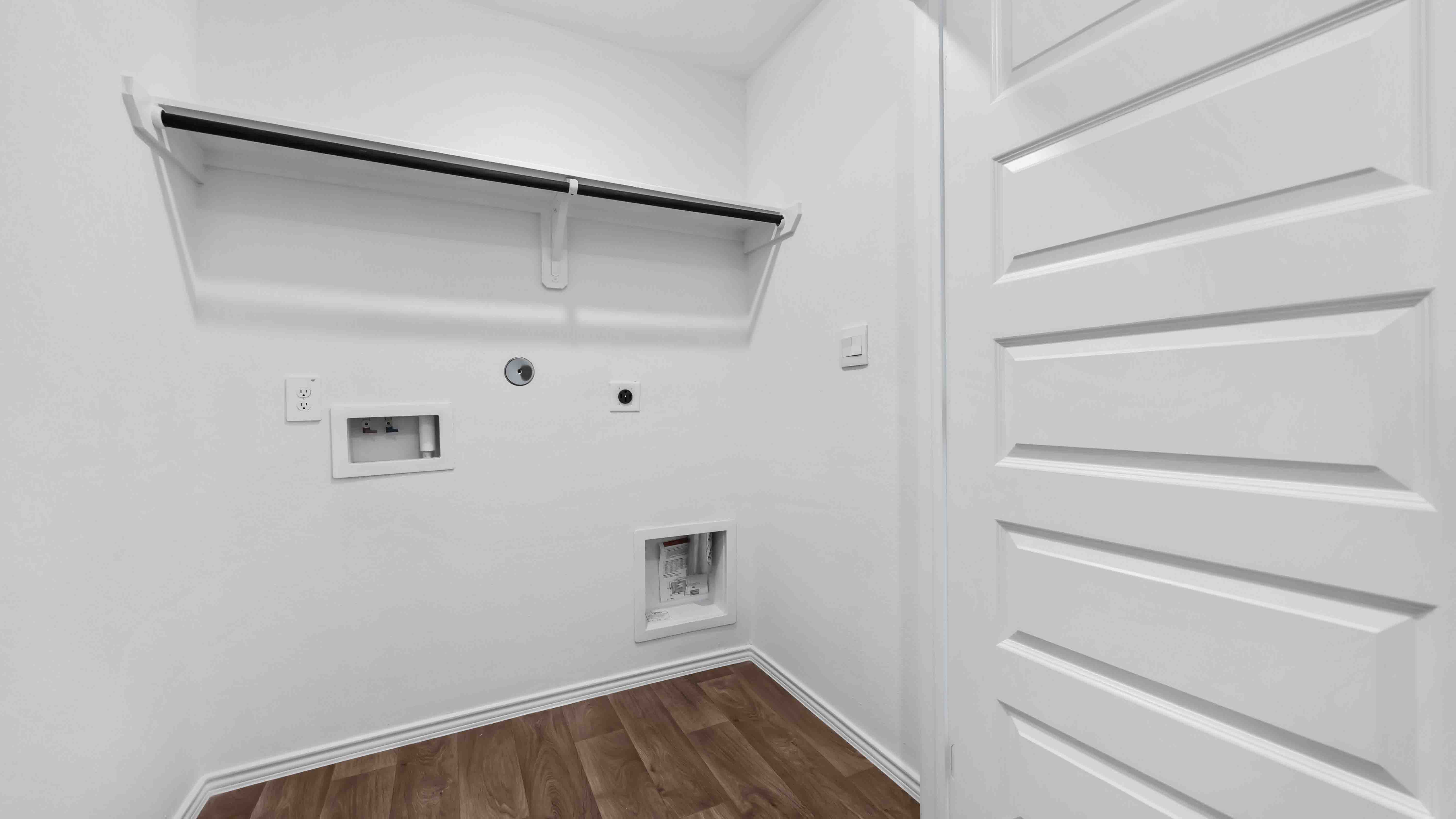 laundry room area with an open shelf and rod for additional storage and hanging clothes