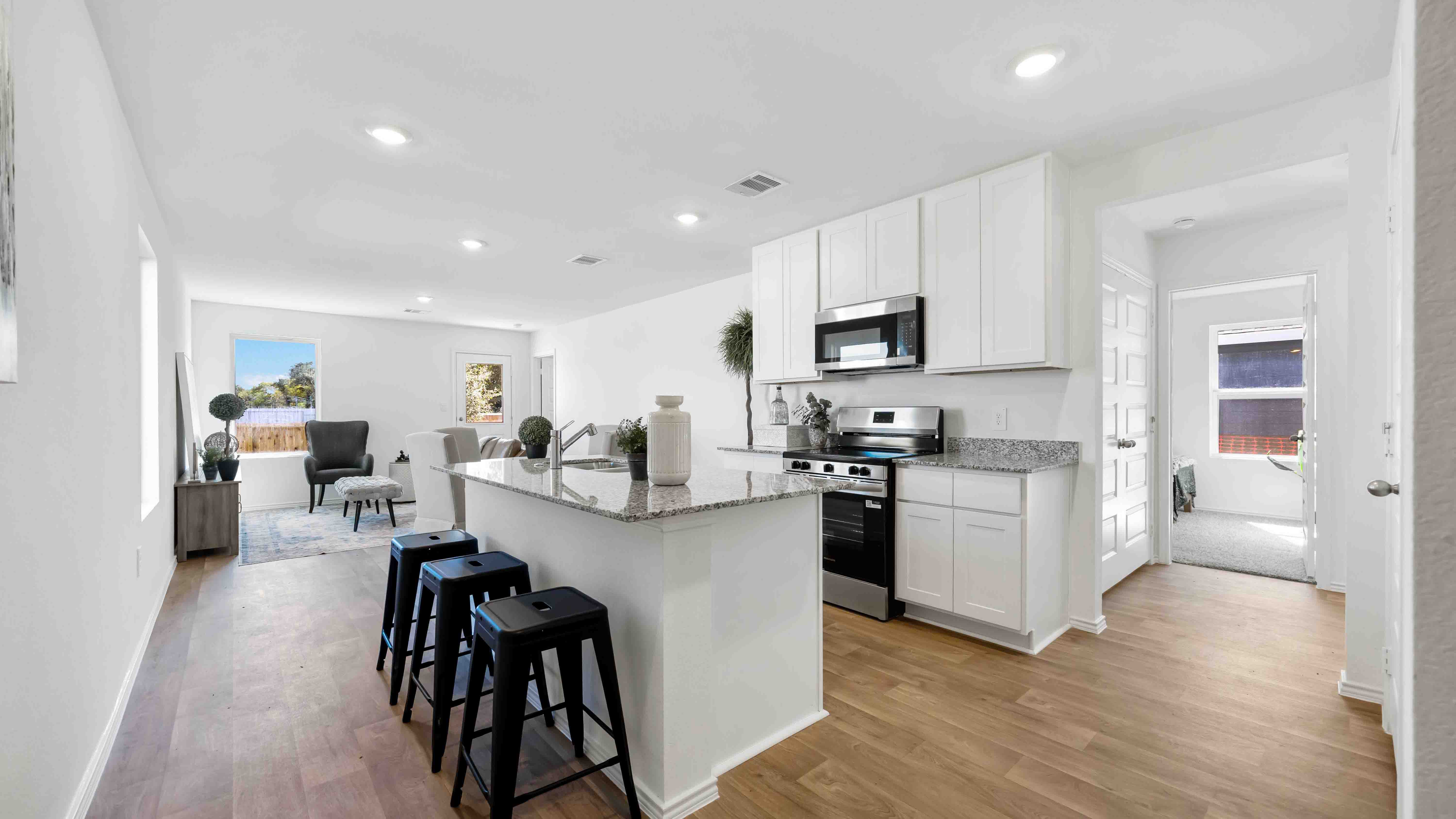 Bright and spacious kitchen with granite countertops, stainless steel appliances, and an island with bar seating.
