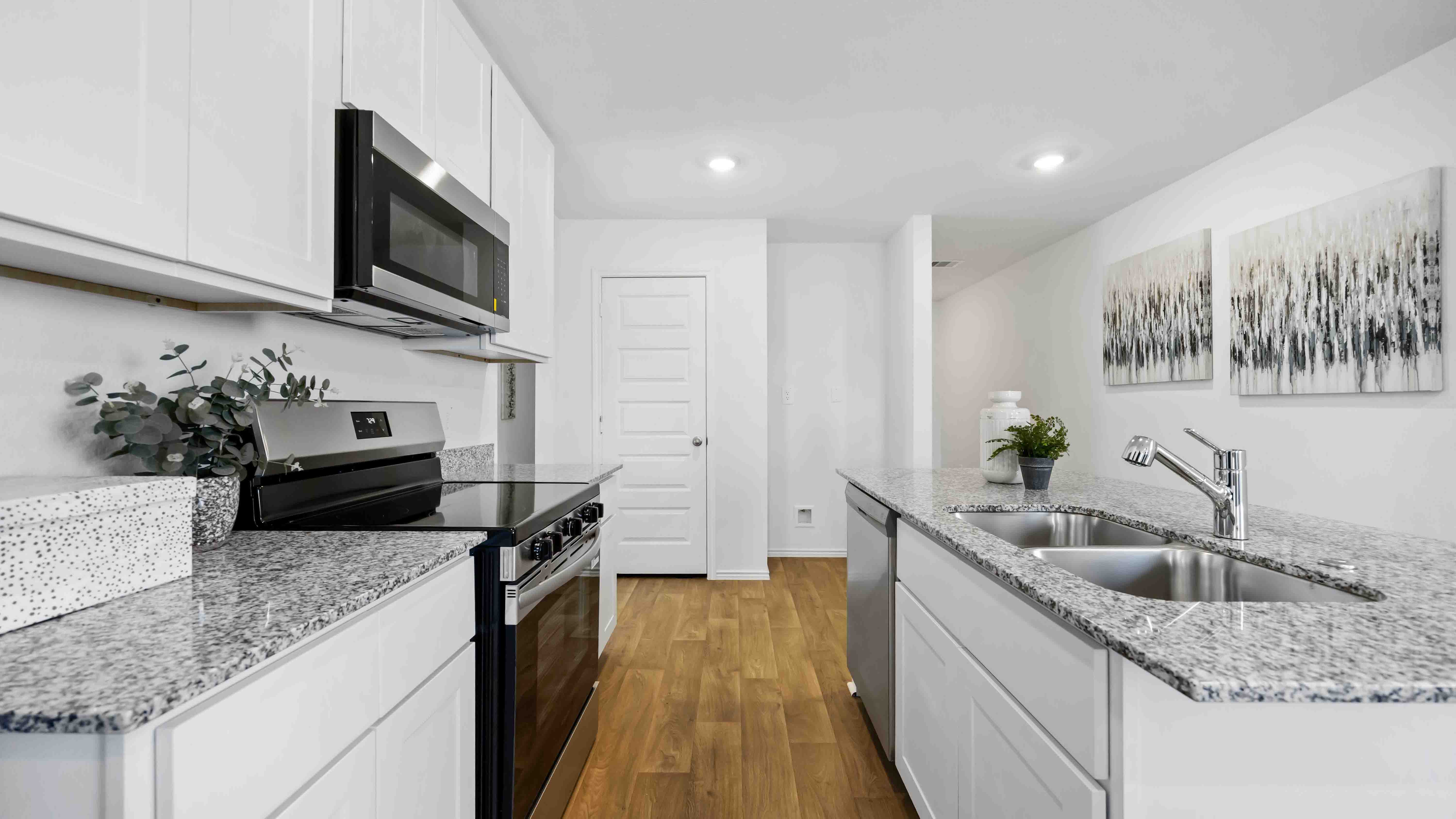 Contemporary kitchen adorned with white cabinets seamlessly integrated into an open dining area layout.