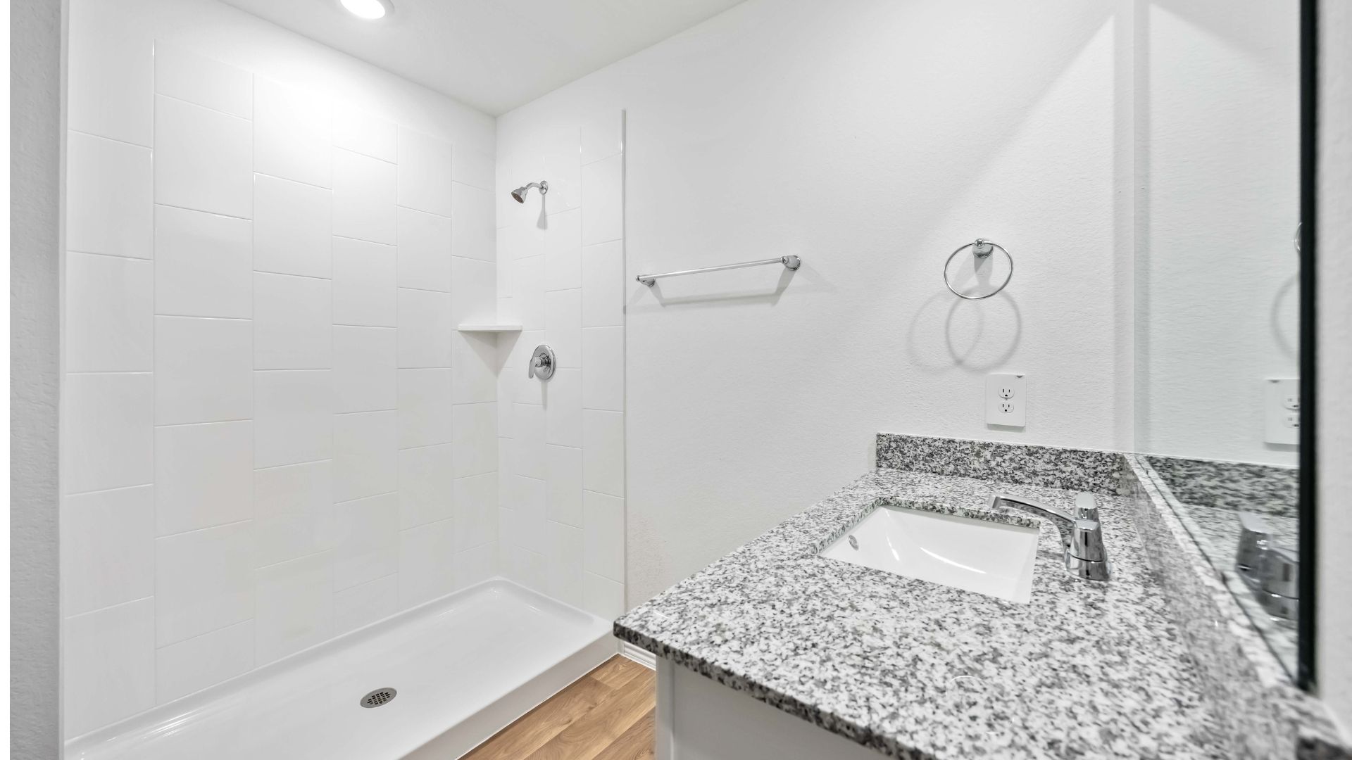 the en-suite primary bathroom has a one sink vanity and a standing shower