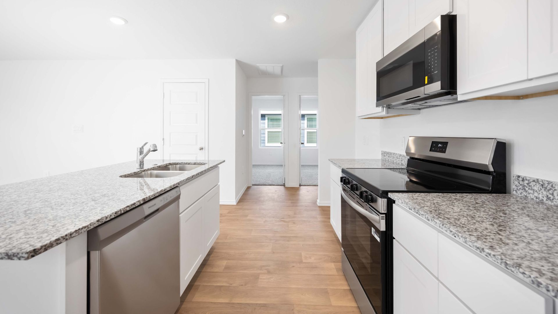 beautiful new kitchen with granite counters and white cabinets