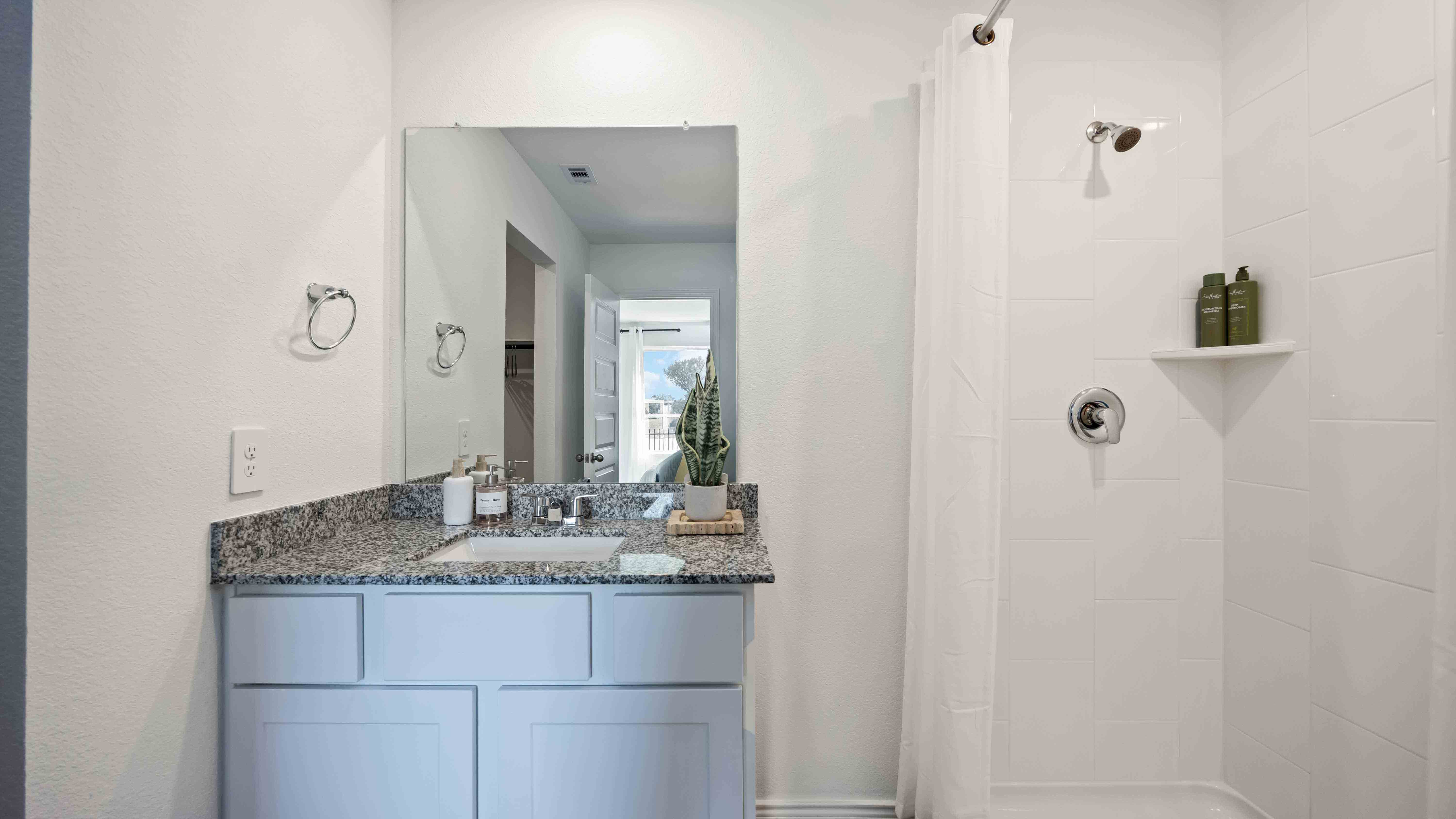 the en-suite primary bathroom has a single vanity and spacious walk-in closet