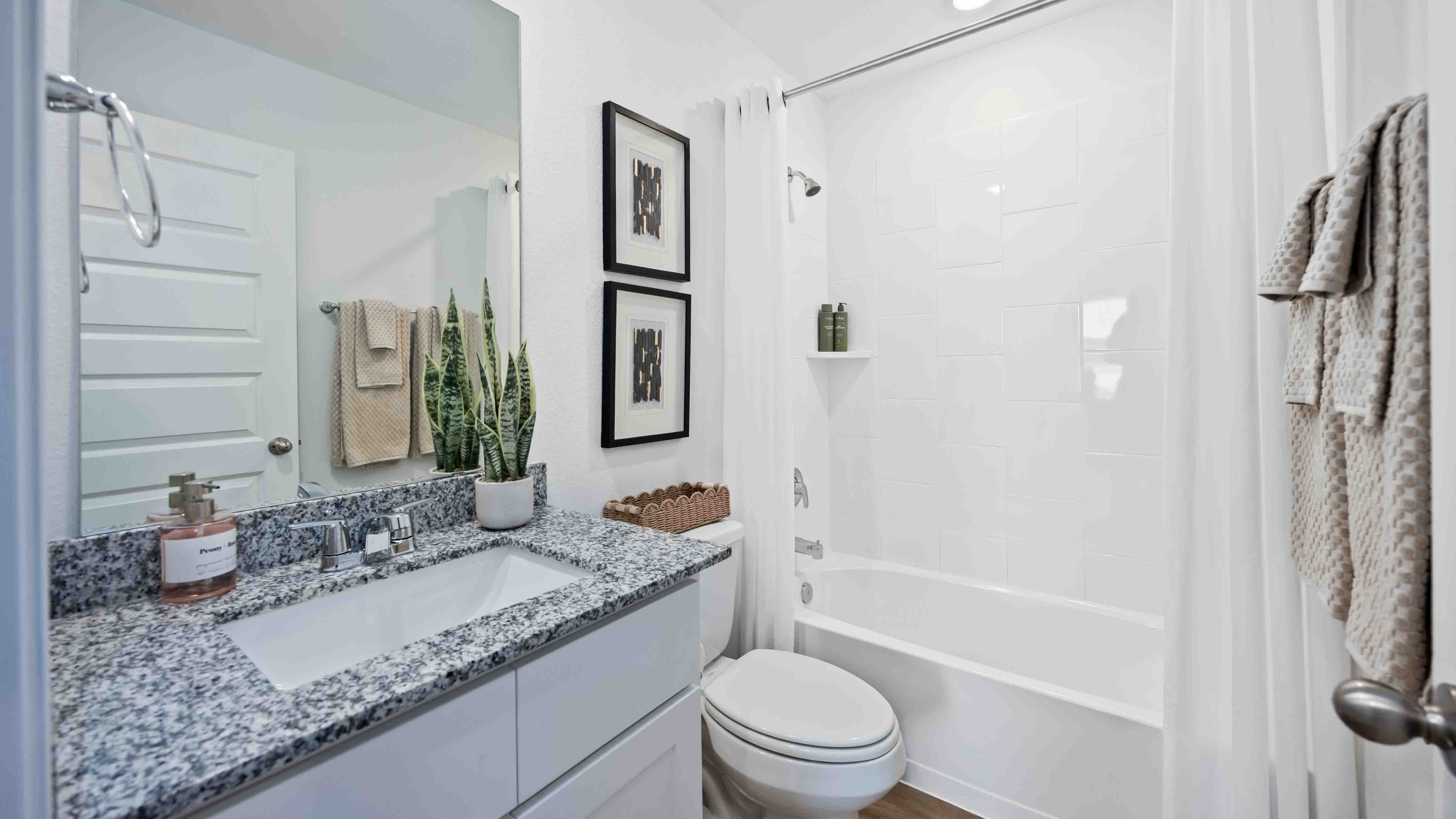 a spacious secondary bathroom with one sink vanity, granite countertops and a standing tub