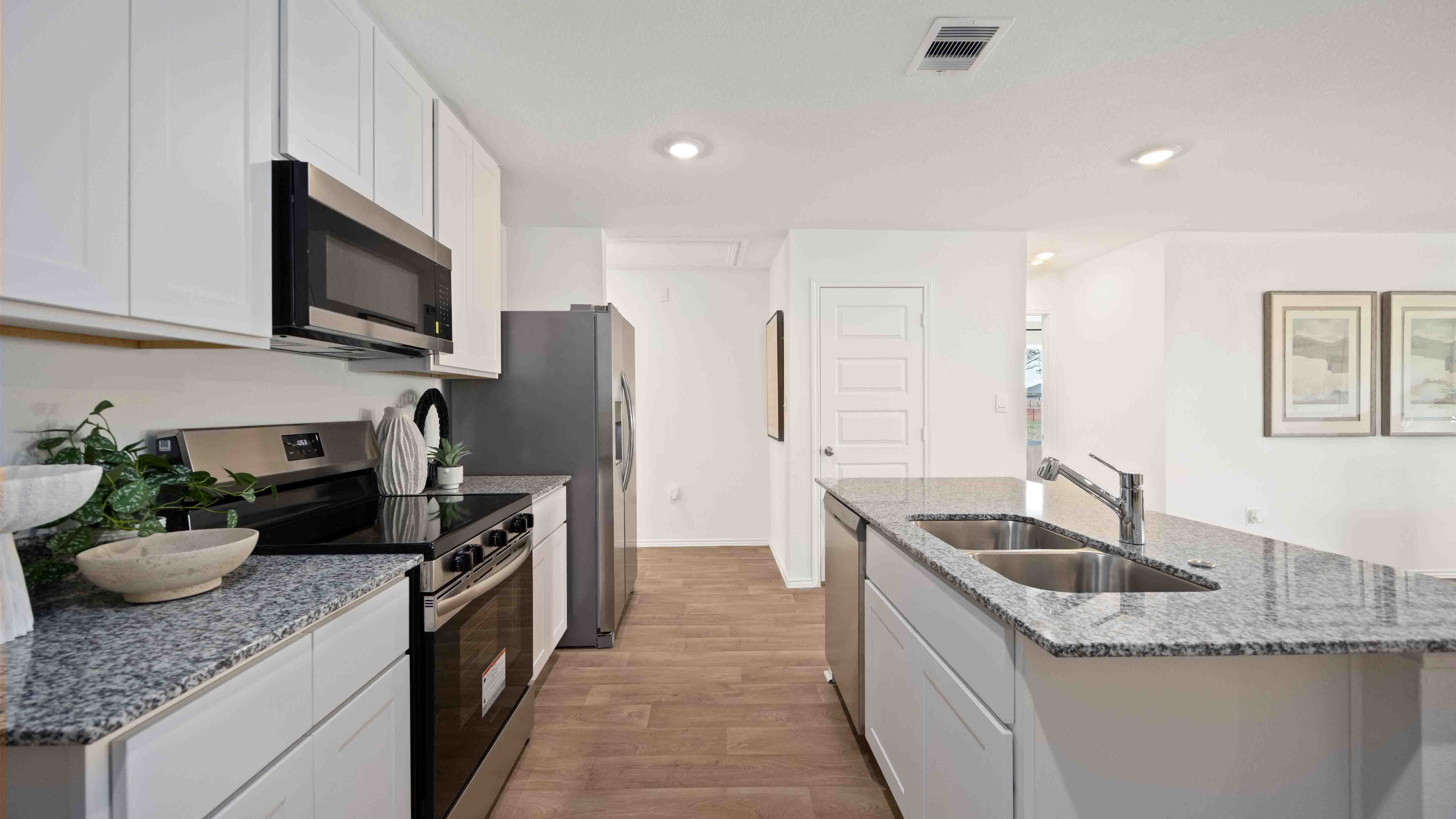 beautiful kitchen with granite counter tops, light cabinets, and an island for additional seating