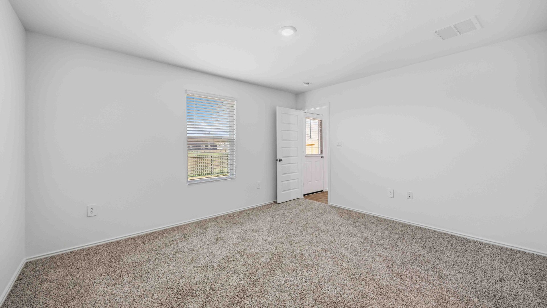 secondary bedrooms have light neutral walls and carpet flooring