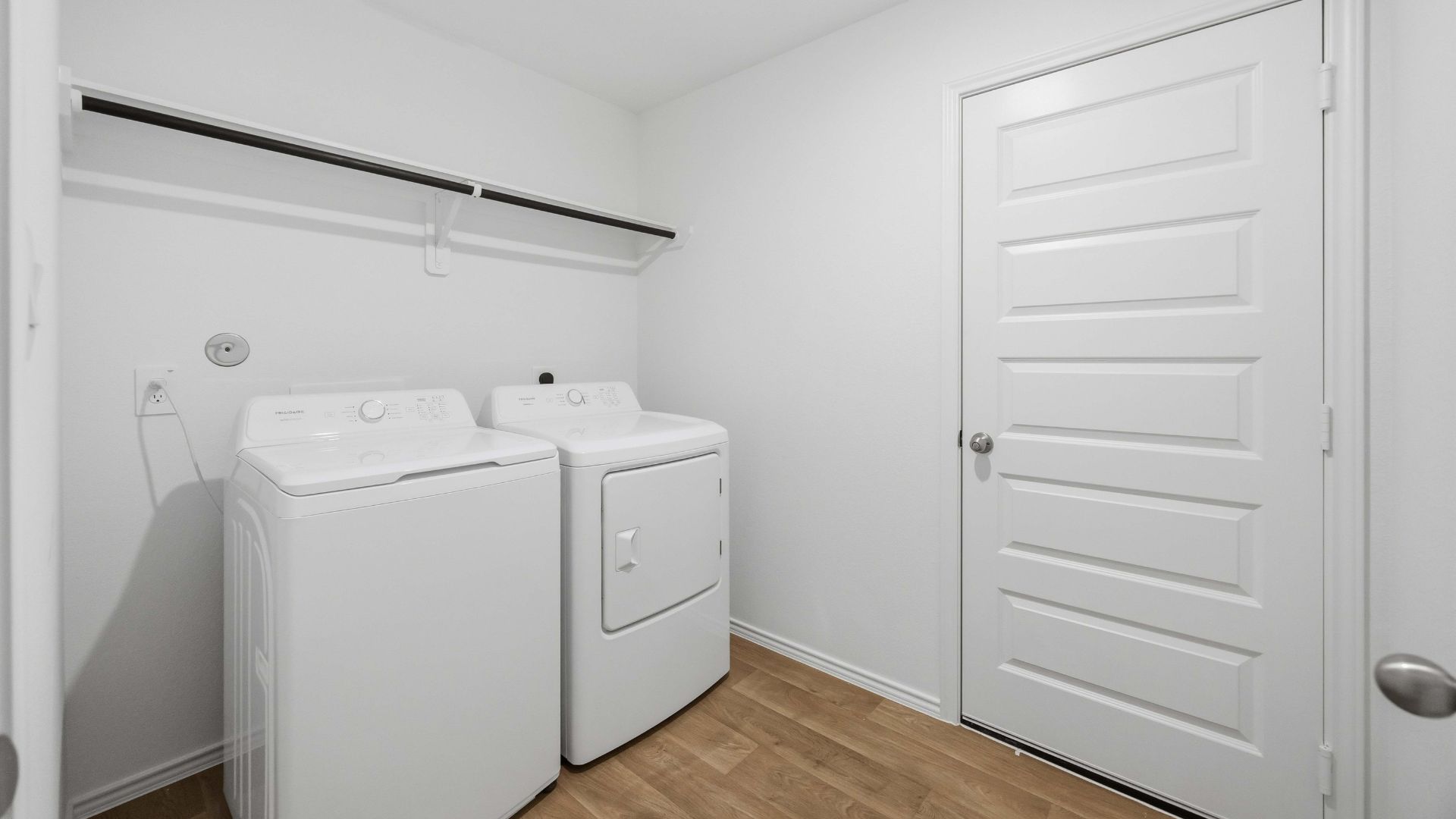 laundry room area with an open shelf and rod for additional storage and hanging clothes