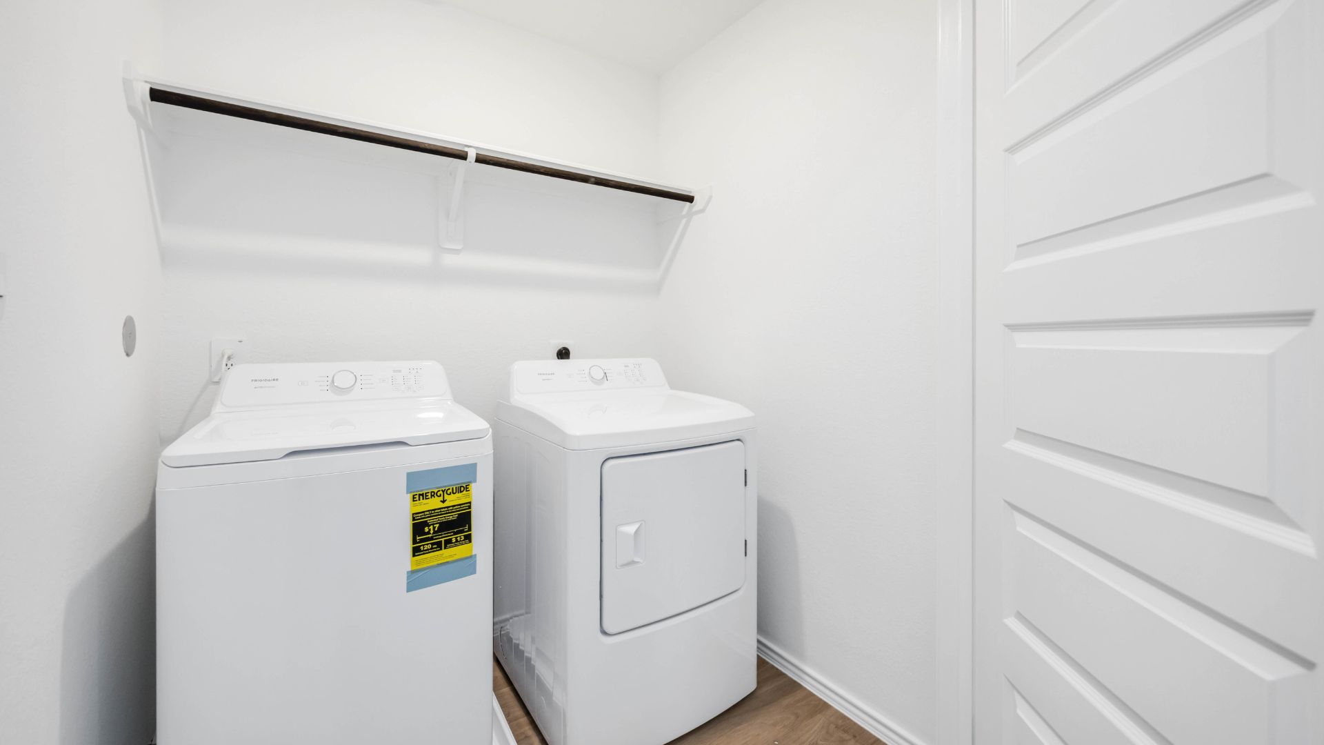 laundry room area with an open shelf and rod for additional storage and hanging clothes