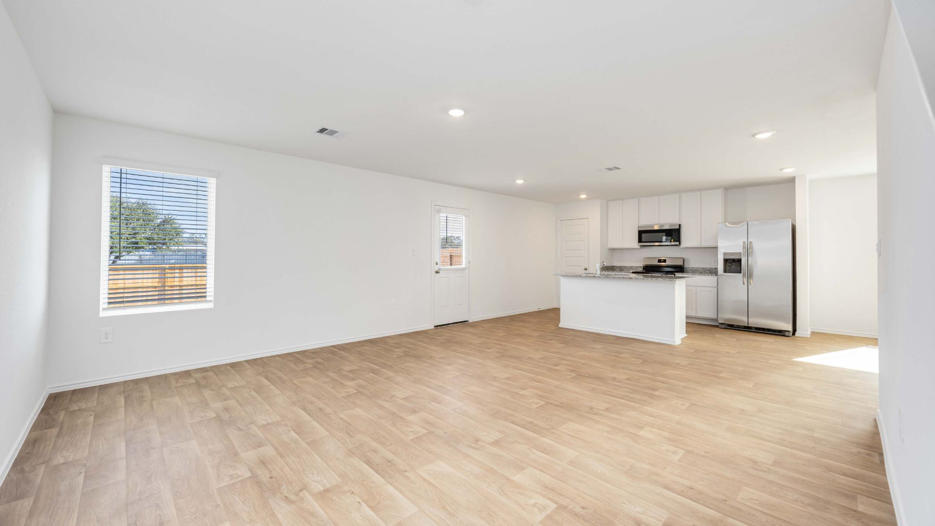 A well-organized living room that includes a kitchen and dining area, creating a warm and welcoming environment for gatherings.