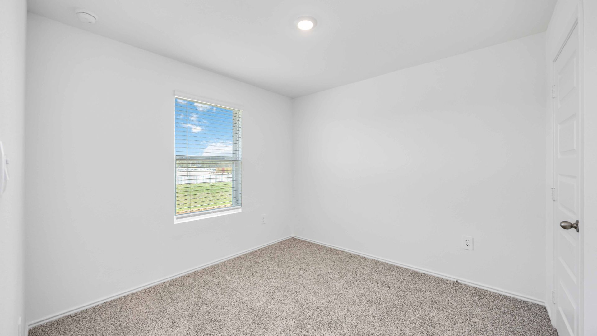 Comfortable third bedroom featuring neutral-toned walls, carpeted flooring, and a separate closet.