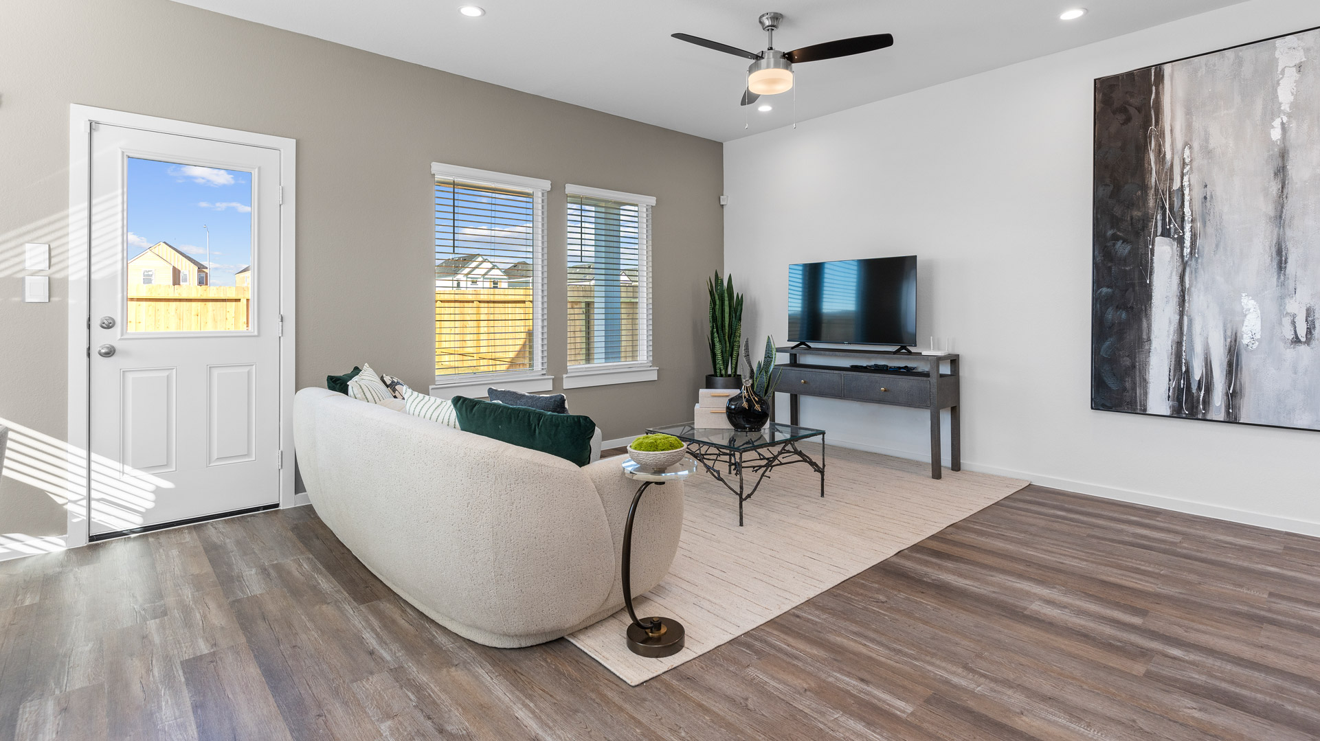 the living room is located at the rear of the home with windows overlooking the backyard