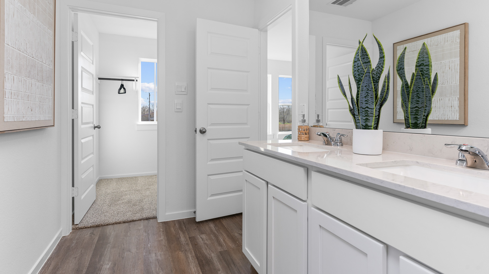 a large mirror is located over the double vanity in the primary bath
