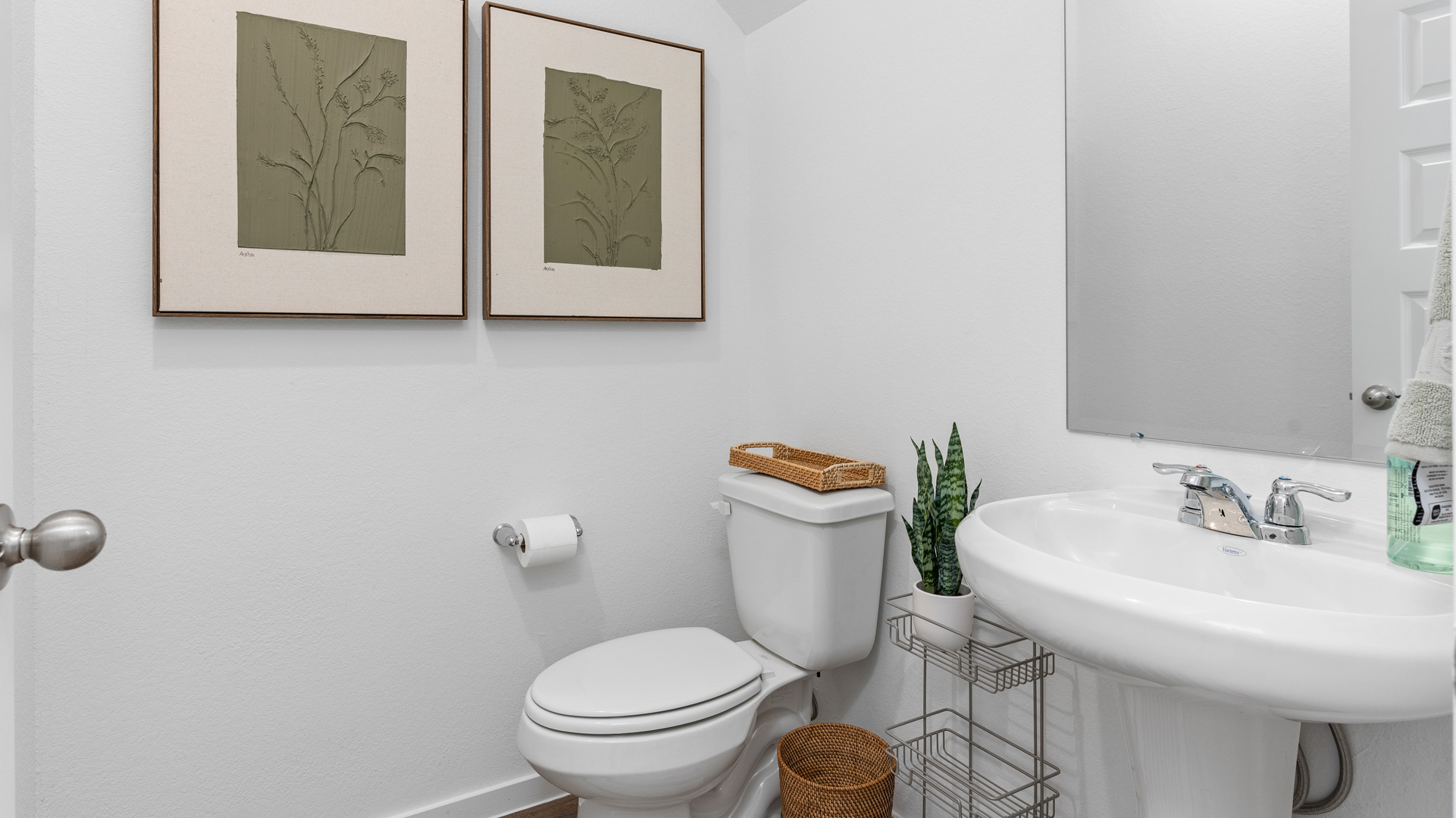 a downstairs powder bathroom has a pedestal sink